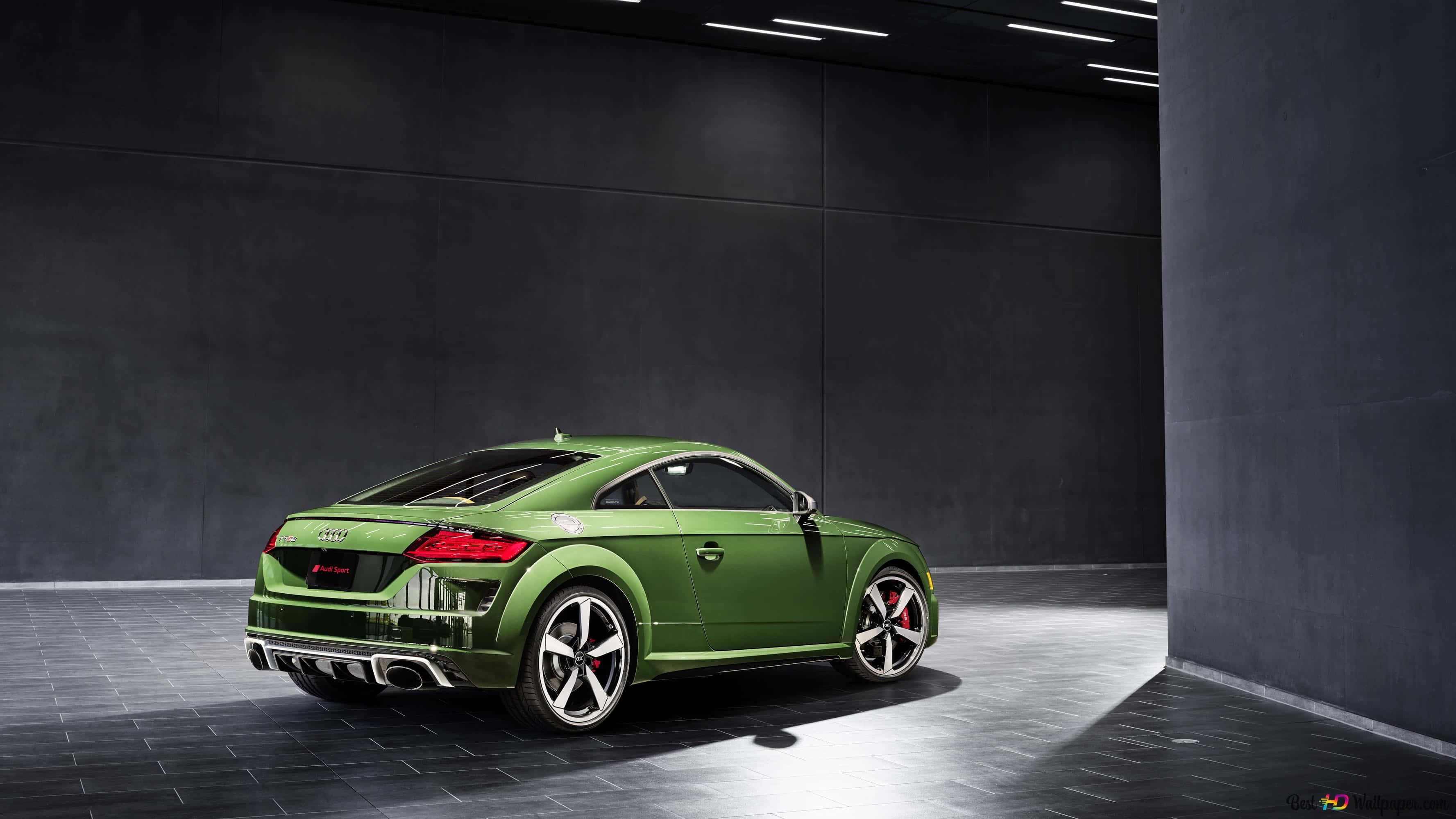 Audi Tt Rs 桌布 壁紙 — 一輛光澤綠色奧迪TT RS跑車在極簡工業車庫中，在戲劇性的聚光燈下展示。