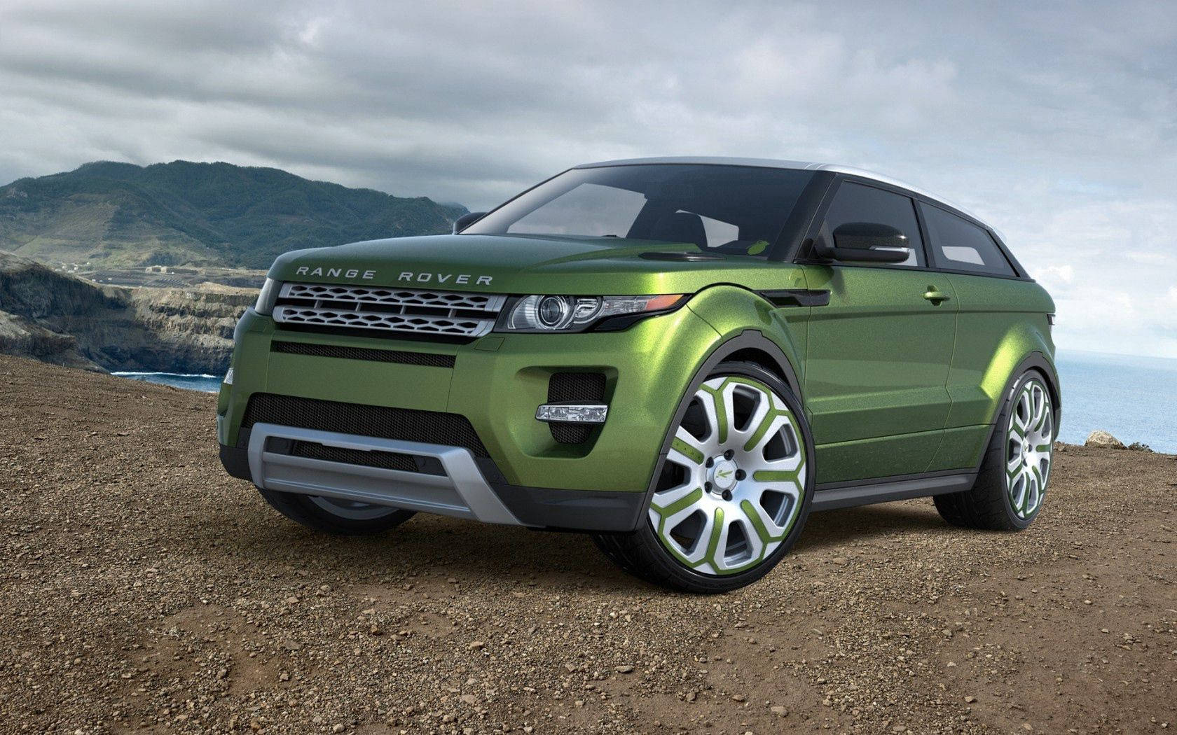 荒原路華 桌布 壁紙 — 一輛光澤綠色的Range Rover Evoque概念車停泊在崎嶇的懸崖邊，俯瞰海洋，天空多雲。