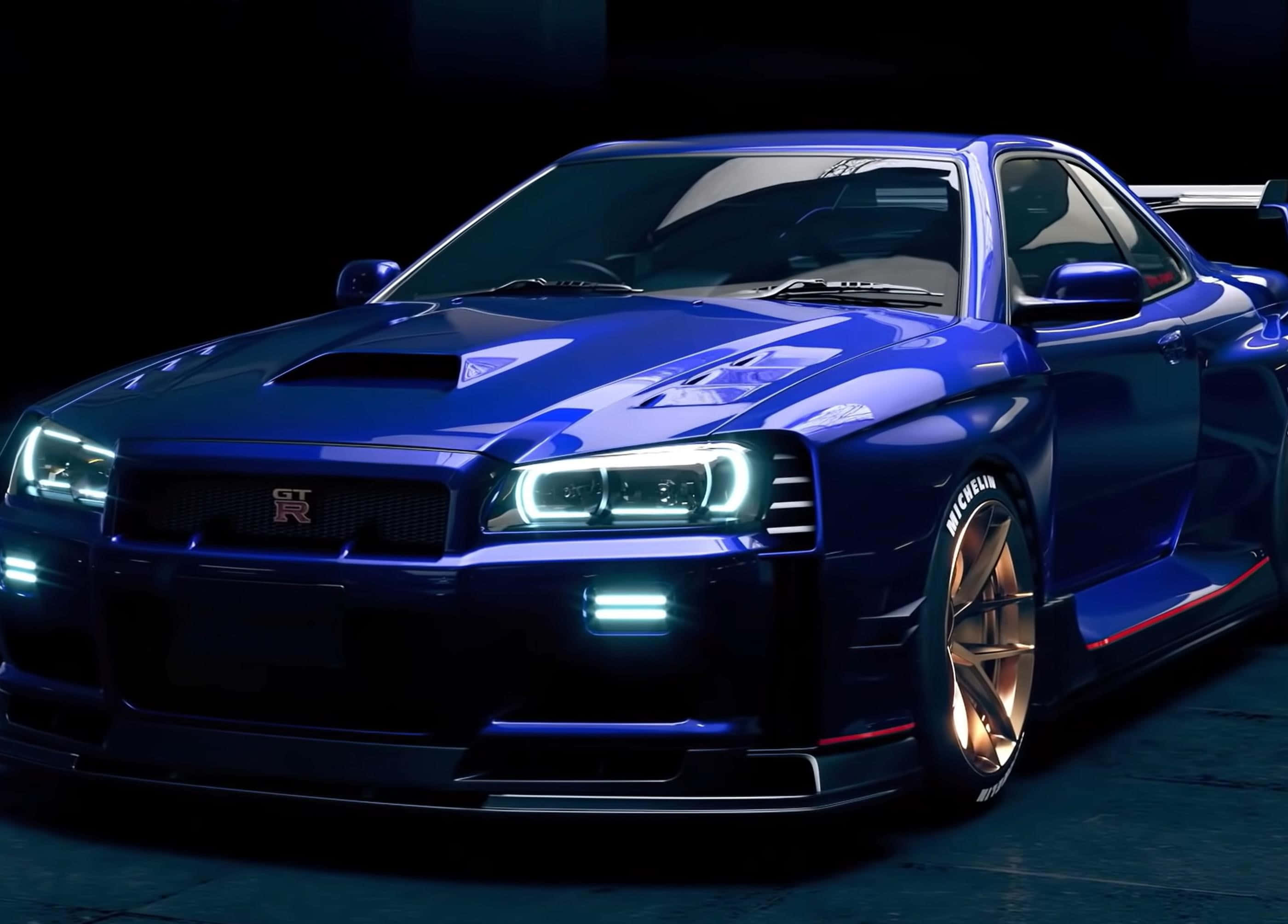 R33 GT-R 桌布 壁紙 — 一輛光澤藍色日產GT-R跑車，配備發光頭燈和金色輪圈，在黑暗的攝影棚中展示。