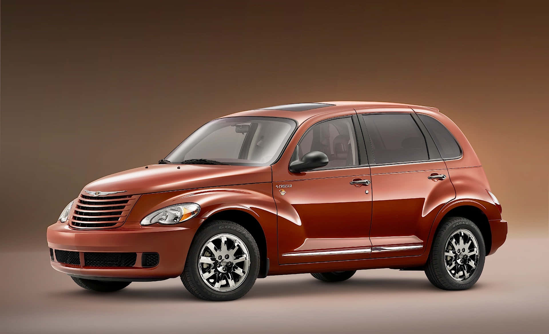 Chrysler Pt Cruiser 桌布 壁紙 — 一輛光澤銅色的PT Cruiser SUV在漸變棕色背景的工作室中。
