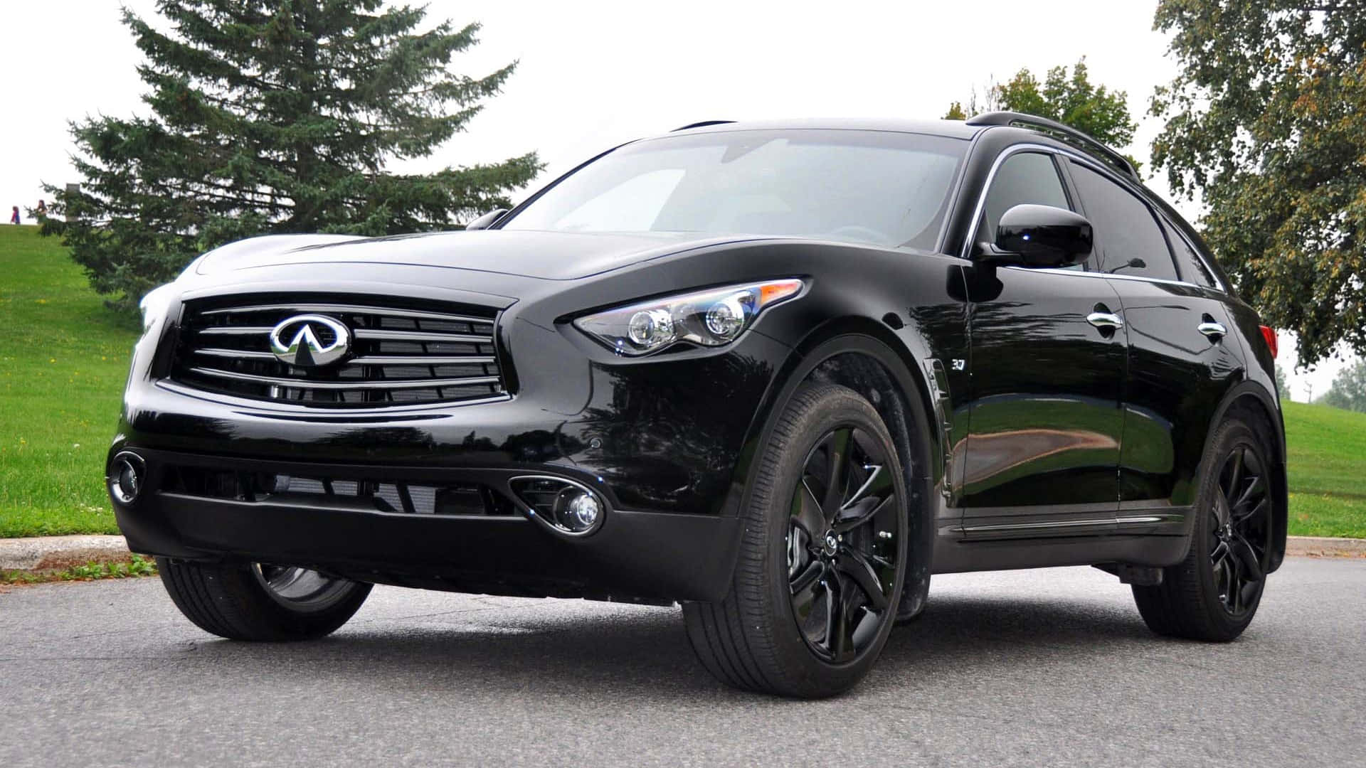 Infiniti Qx70 桌布 壁紙 — 一輛光澤黑色Infiniti FX35 SUV停放在柏油路上，背景有綠草和樹木。