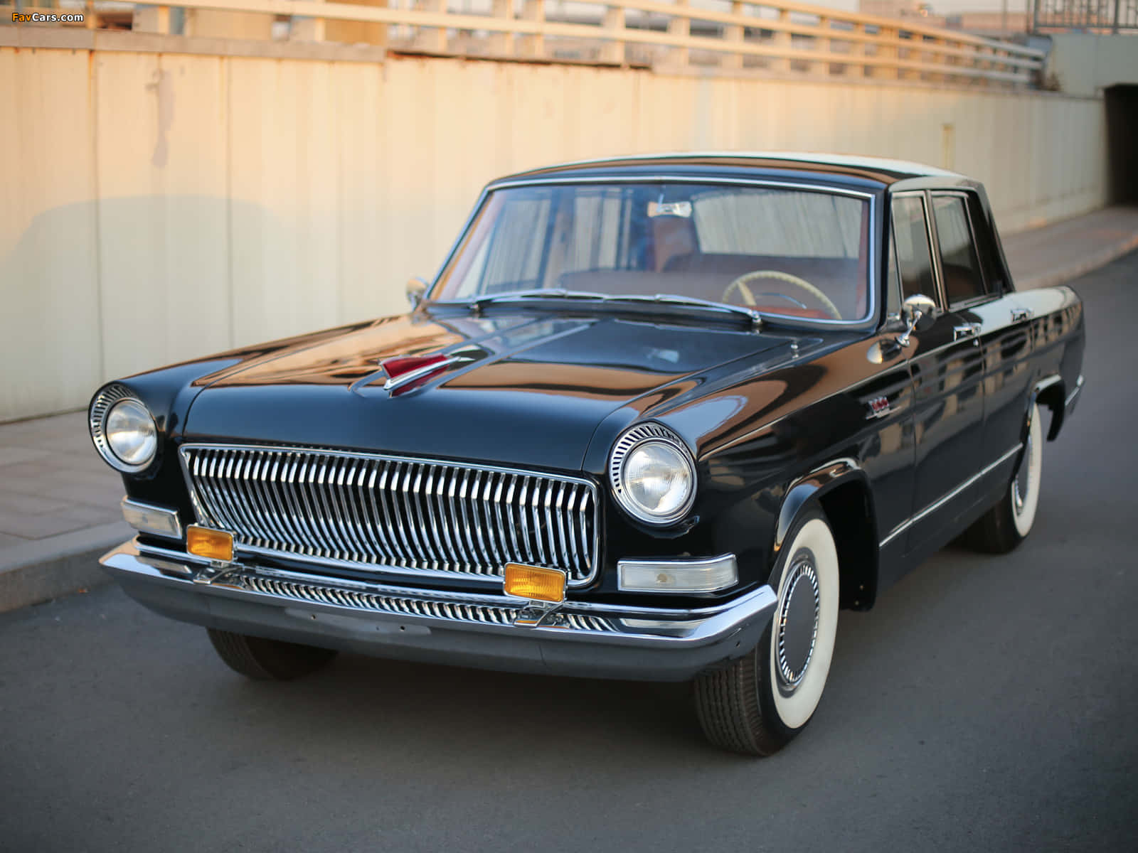 Hongqi 桌布 壁紙 — 一輛光澤黑色復古轎車，帶有鍍鉻格柵和白色輪胎，在黃金時段停泊在街道上。