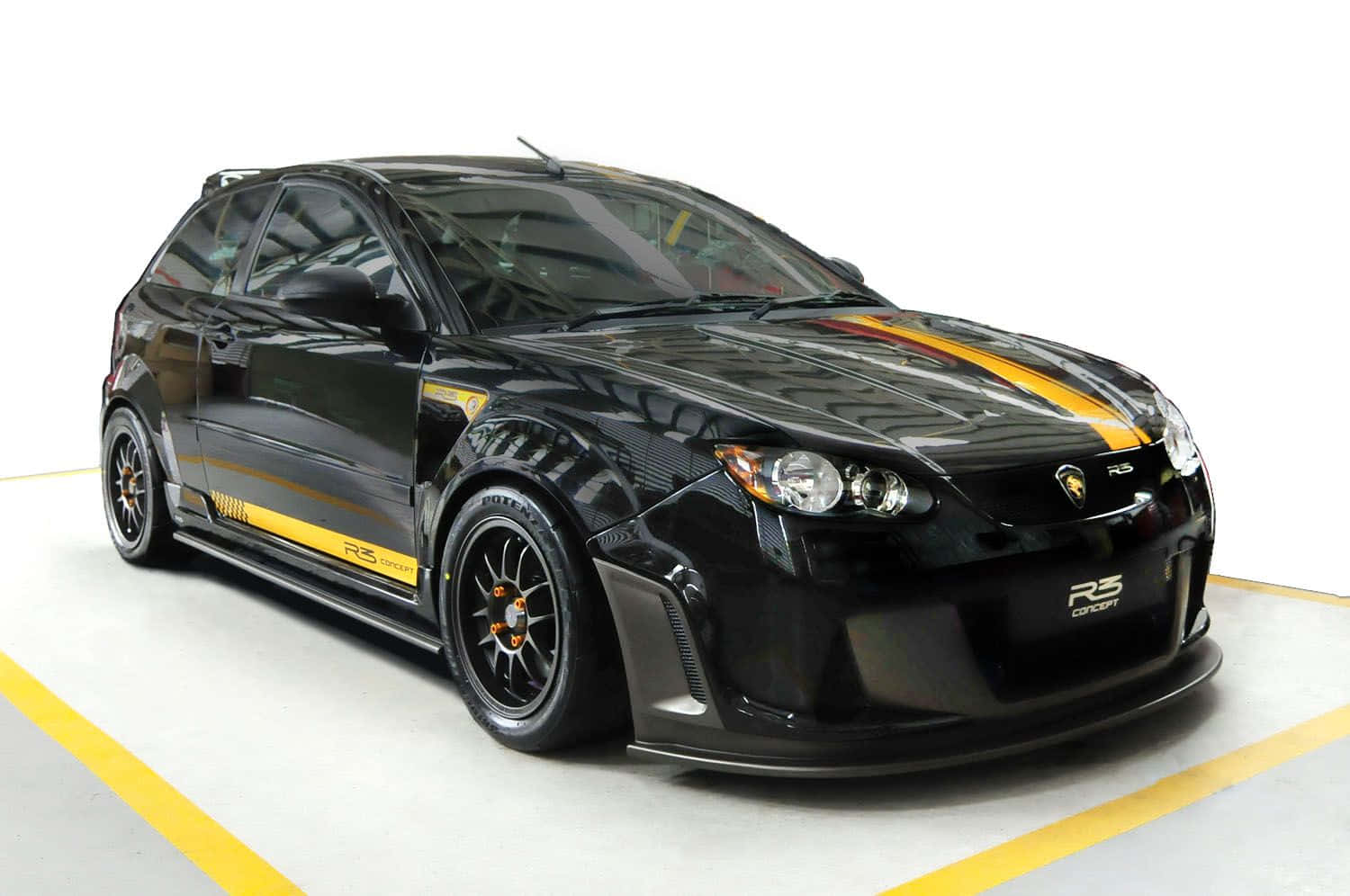 Proton 桌布 壁紙 — 一輛光澤黑色蓮花R3概念賽車，帶有醒目的黃色條紋和黑色輪圈，停放在一個明亮的白色工作室中，地板上有黃色標記。