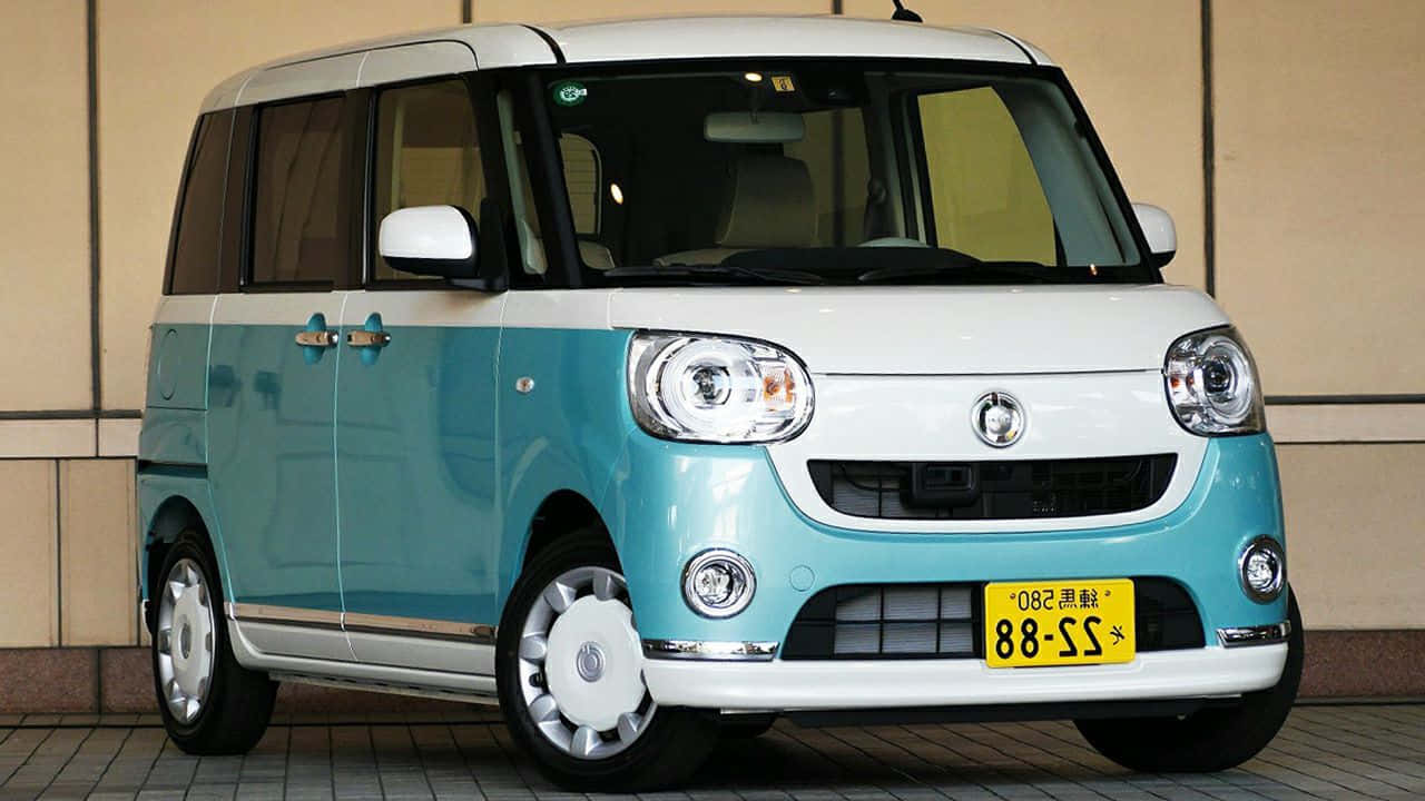 Daihatsu 桌布 壁紙 — 一輛可愛的藍綠色和白色小型廂型車停放在瓷磚鋪設的路面上，背景是米色牆壁。