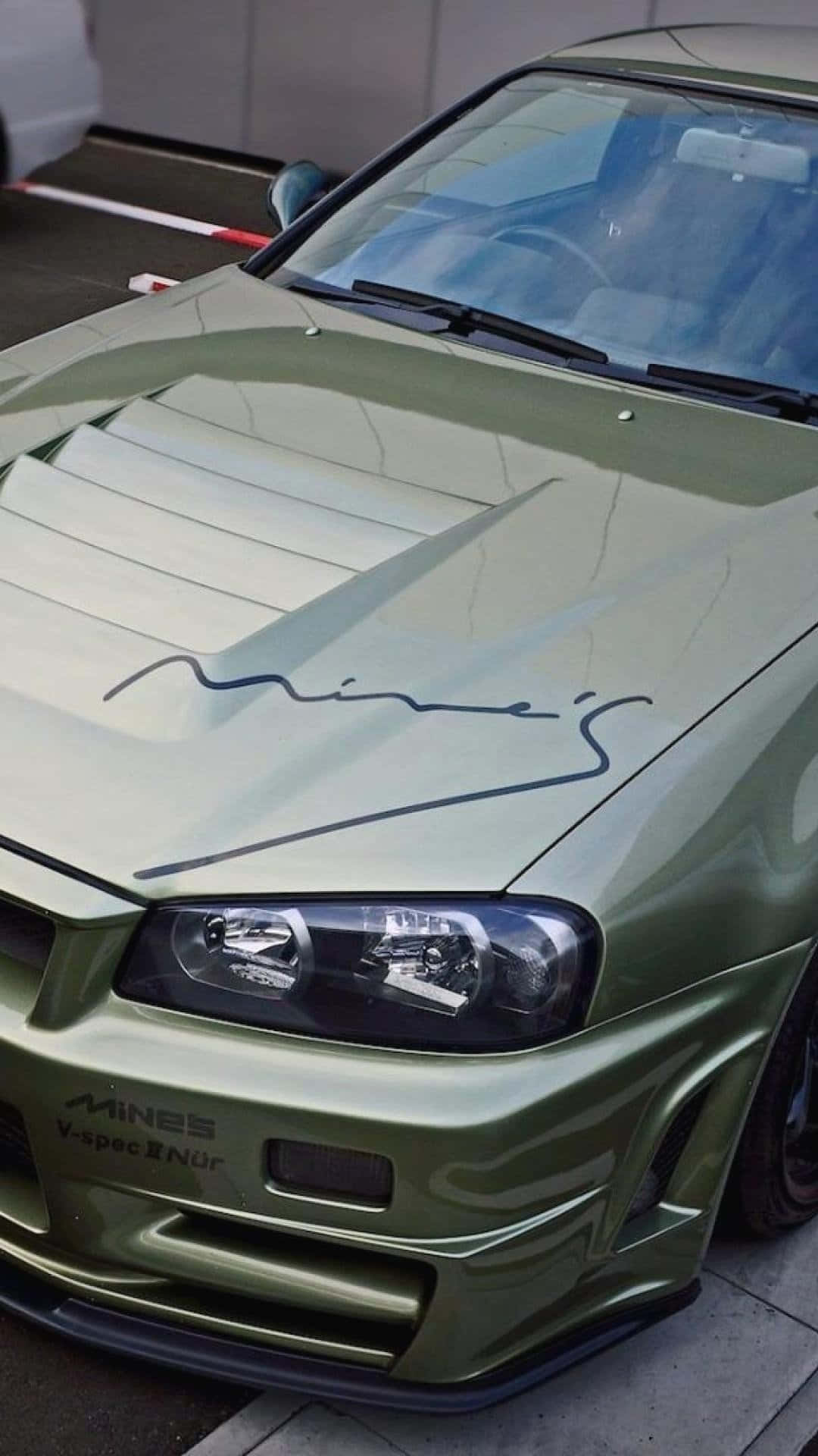 JDM 桌布 壁紙 — 一輛啞光橄欖綠改裝跑車的特寫，帶有 'Mines' 品牌標誌和定制引擎蓋進氣口，停在路面上。