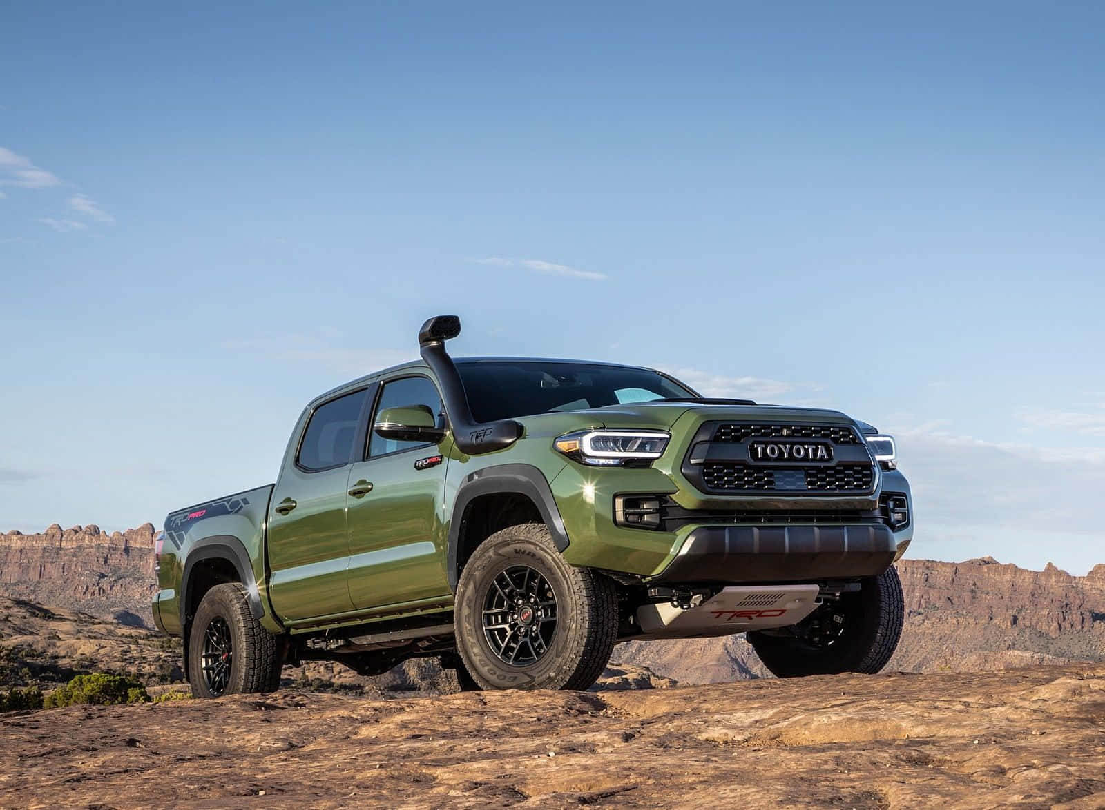 橄欖綠色的豐田Tacoma TRD Pro皮卡車在藍天下的岩石沙漠地形上。 — Toyota Supra Mk4 壁紙