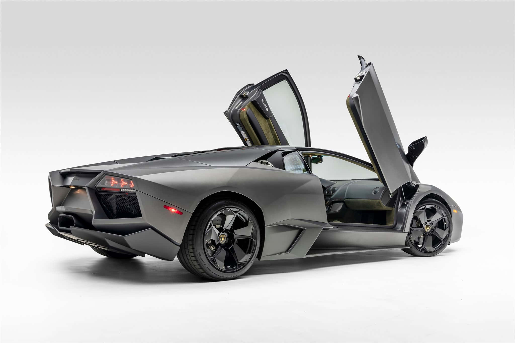 Lamborghini Reventón 桌布 壁紙 — 一輛啞光灰色的藍寶堅尼，剪刀門打開，背景是潔淨的白色攝影棚。
