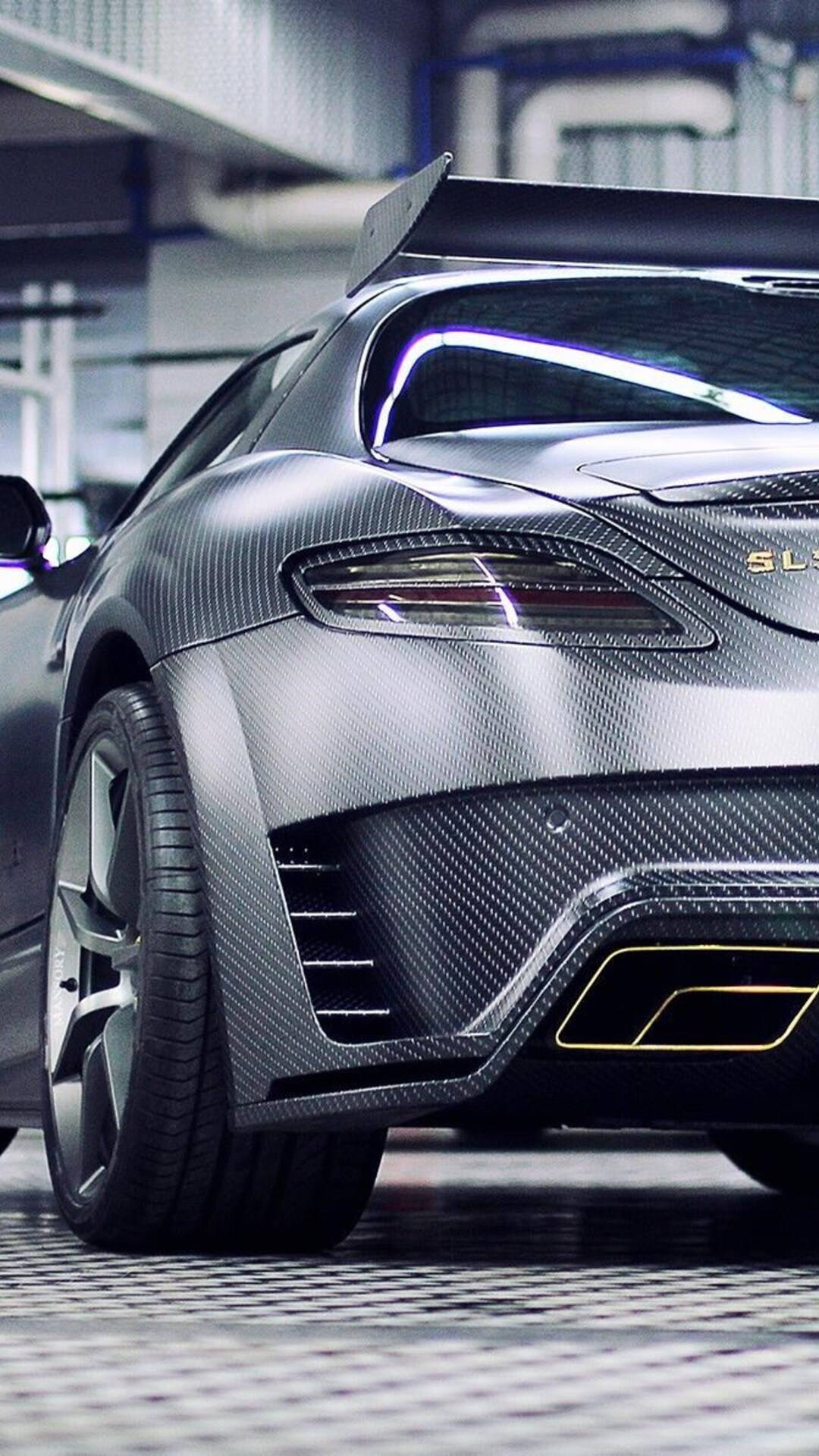 amg iPhone 桌布 壁紙 — 一輛啞光灰色碳纖維跑車，帶有發光的尾燈，停放在高科技車庫中。
