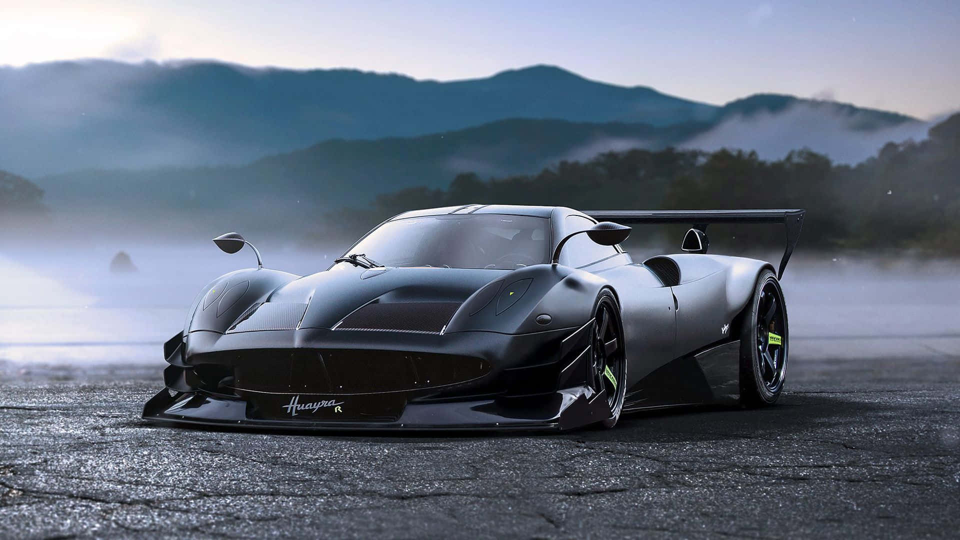 跑車 桌布 壁紙 — 一輛啞光黑色的Huayra Roadster在黎明時分，在潮濕的瀝青賽道上漂移，背景是霧氣繚繞的山脈。