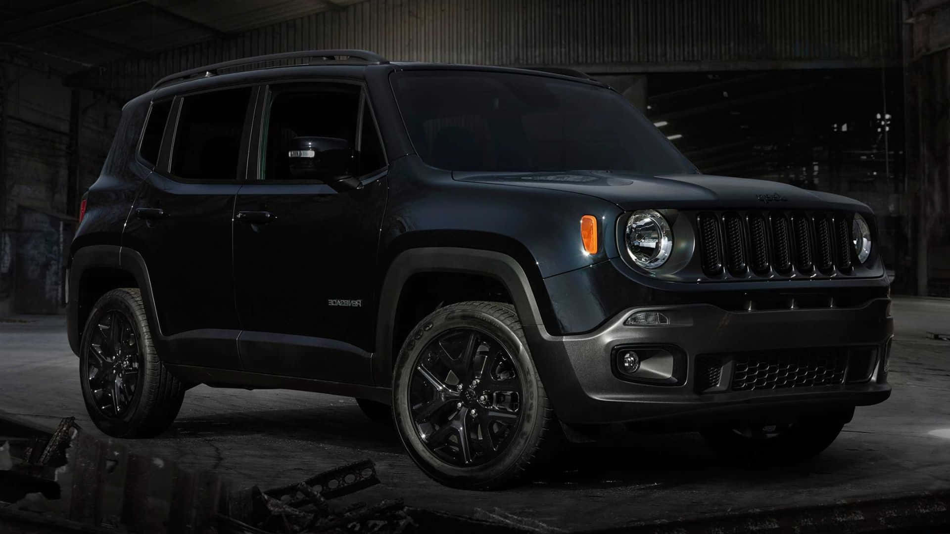 Jeep Renegade 桌布 壁紙 — 一輛啞黑色Jeep Renegade SUV在一個粗糙的工業倉庫中，在裸露的橫樑和散落的碎片下被戲劇性地照亮。