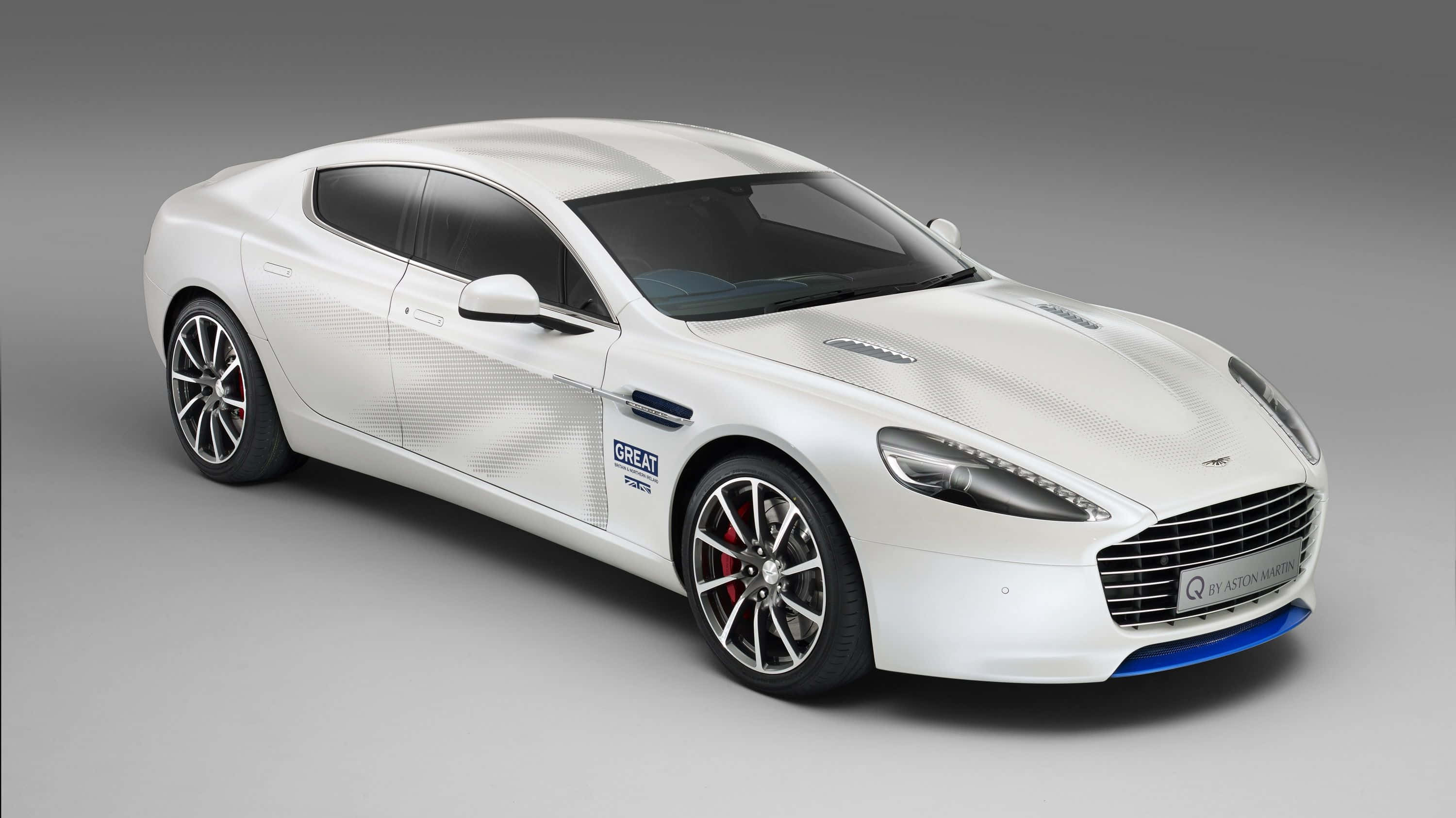 Aston Martin Rapide S 桌布 壁紙 — 一輛在攝影棚內展示的白色Aston Martin跑車，帶有藍色飾條和'GREAT'品牌標識，造型流暢。