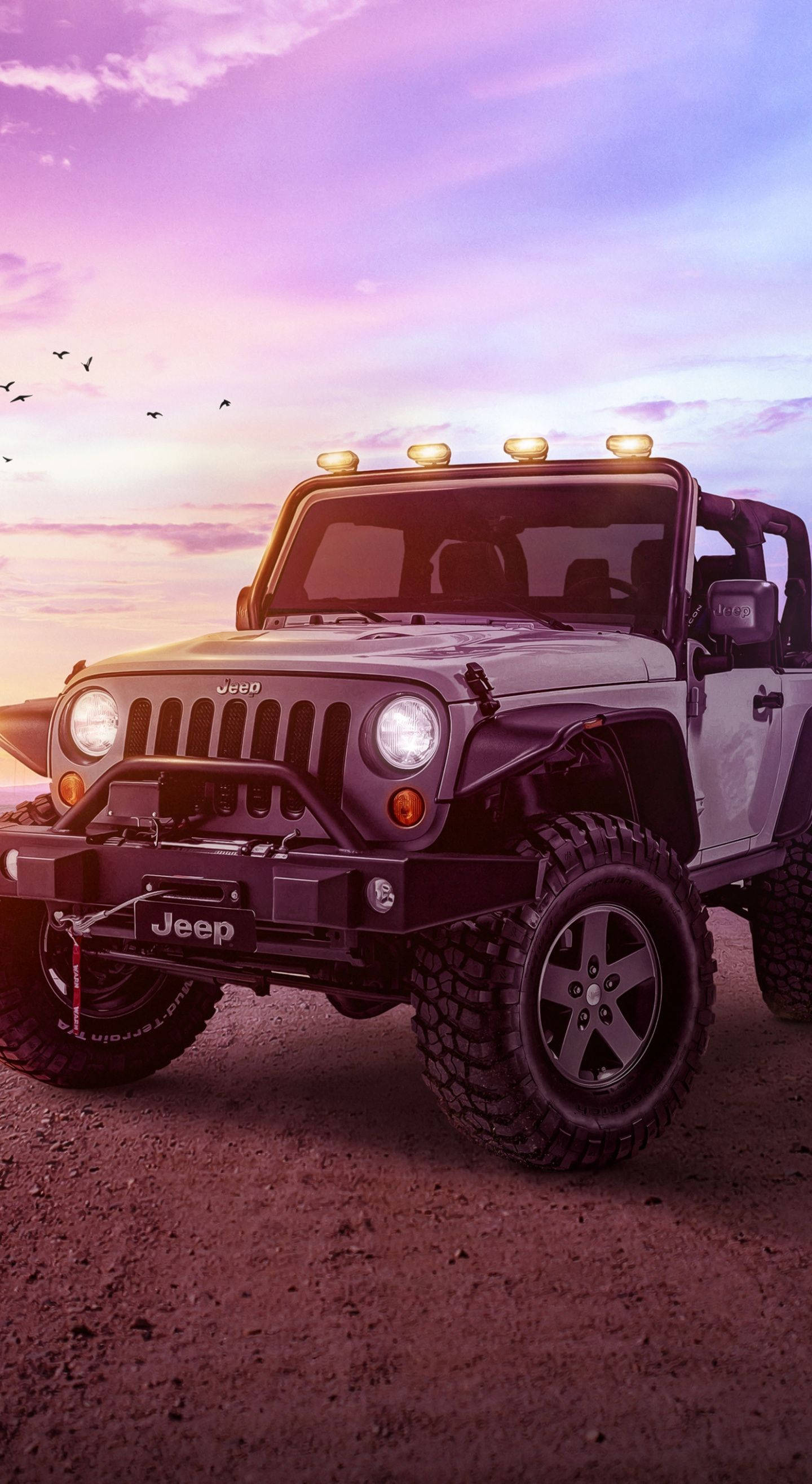 Wrangler 桌布 壁紙 — 一輛堅固的白色Jeep Wrangler配備車頂燈，站在塵土飛揚的地形上，天空是充滿活力的紫色和粉紅色日落，鳥兒飛翔。