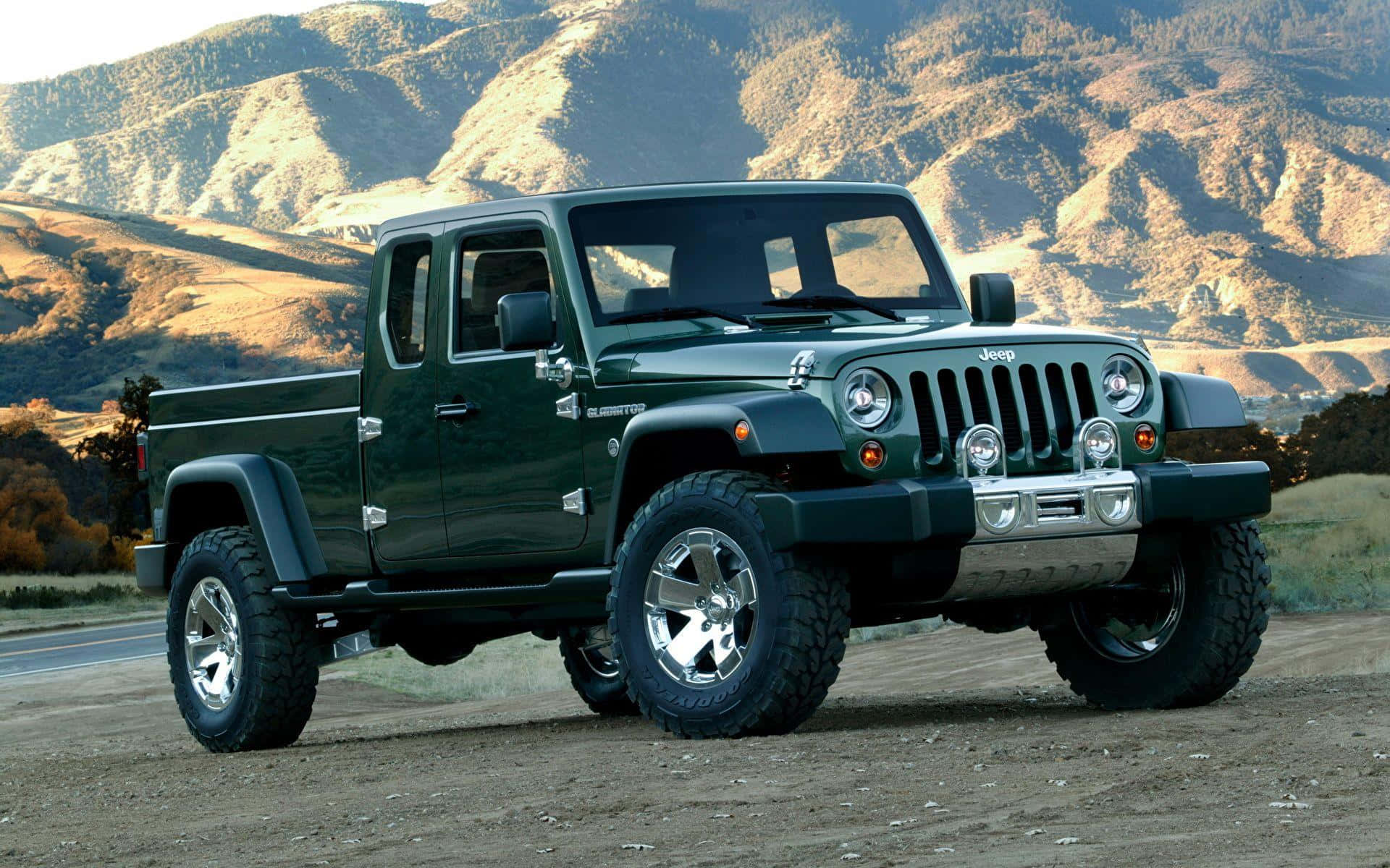 Jeep Gladiator 桌布 壁紙 — 一輛堅固的綠色Jeep Gladiator pickup卡車停泊在泥土上，背景是山區地形，在明亮的日光下。