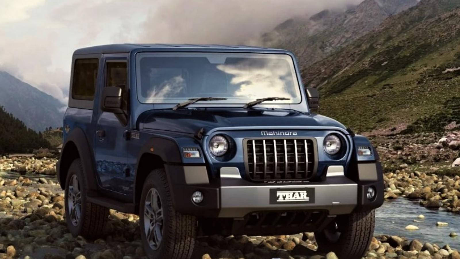 吉普 桌布 壁紙 — 一輛堅固的藍色Mahindra Thar SUV停在岩石河床上，後面是煙霧繚繞的山脈。