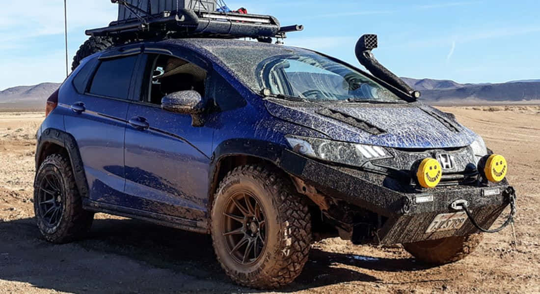 Off-road Car 桌布 壁紙 — 一輛堅固的藍色本田SUV覆蓋著泥濘，準備在晴朗藍天下於廣闊沙漠中進行越野駕駛。