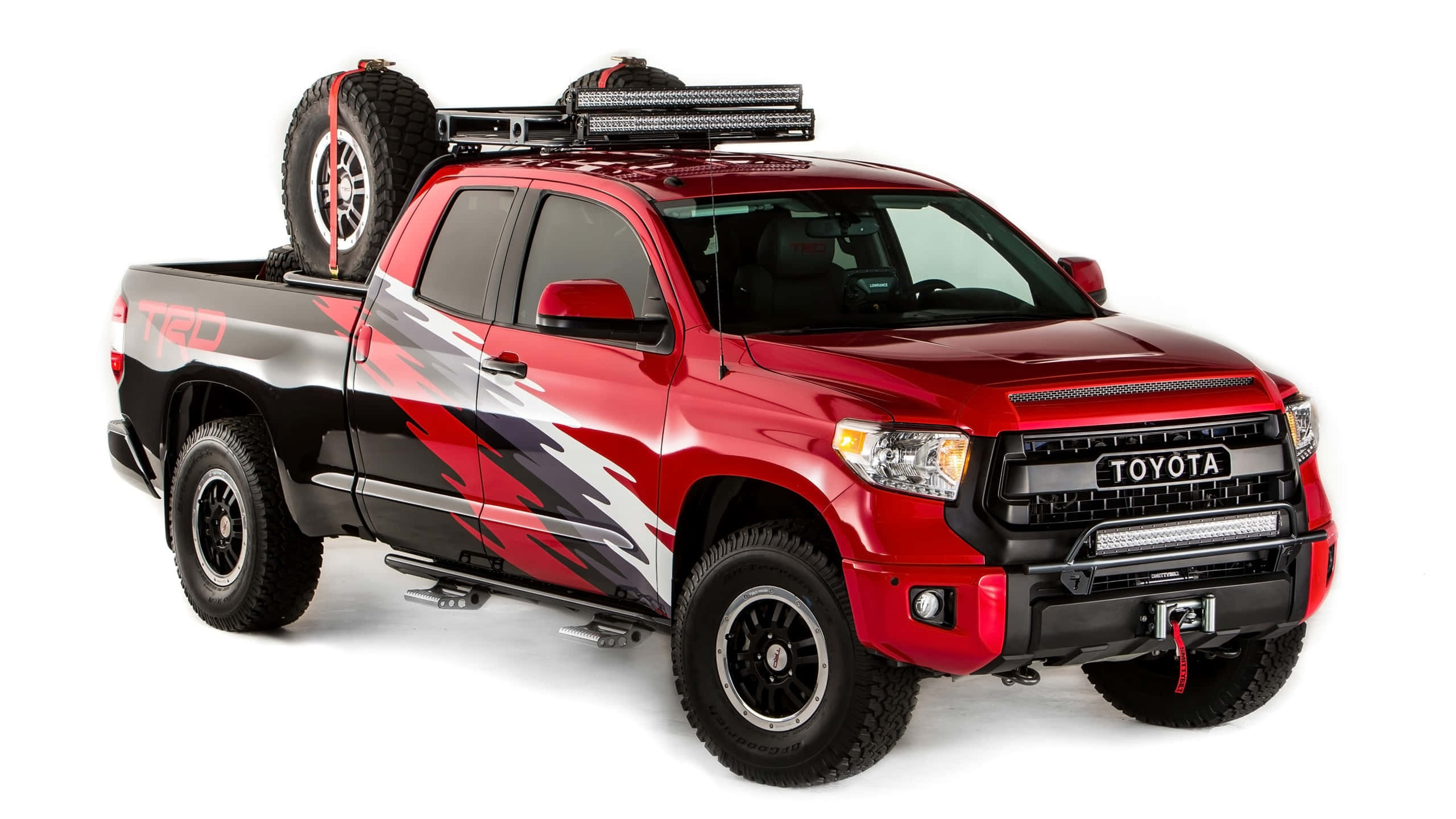 Toyota 桌布 壁紙 — 一輛大膽的紅色豐田 Tacoma TRD 皮卡車，帶有黑色飾件和一個裝有備胎和 LED 燈的車頂行李架。