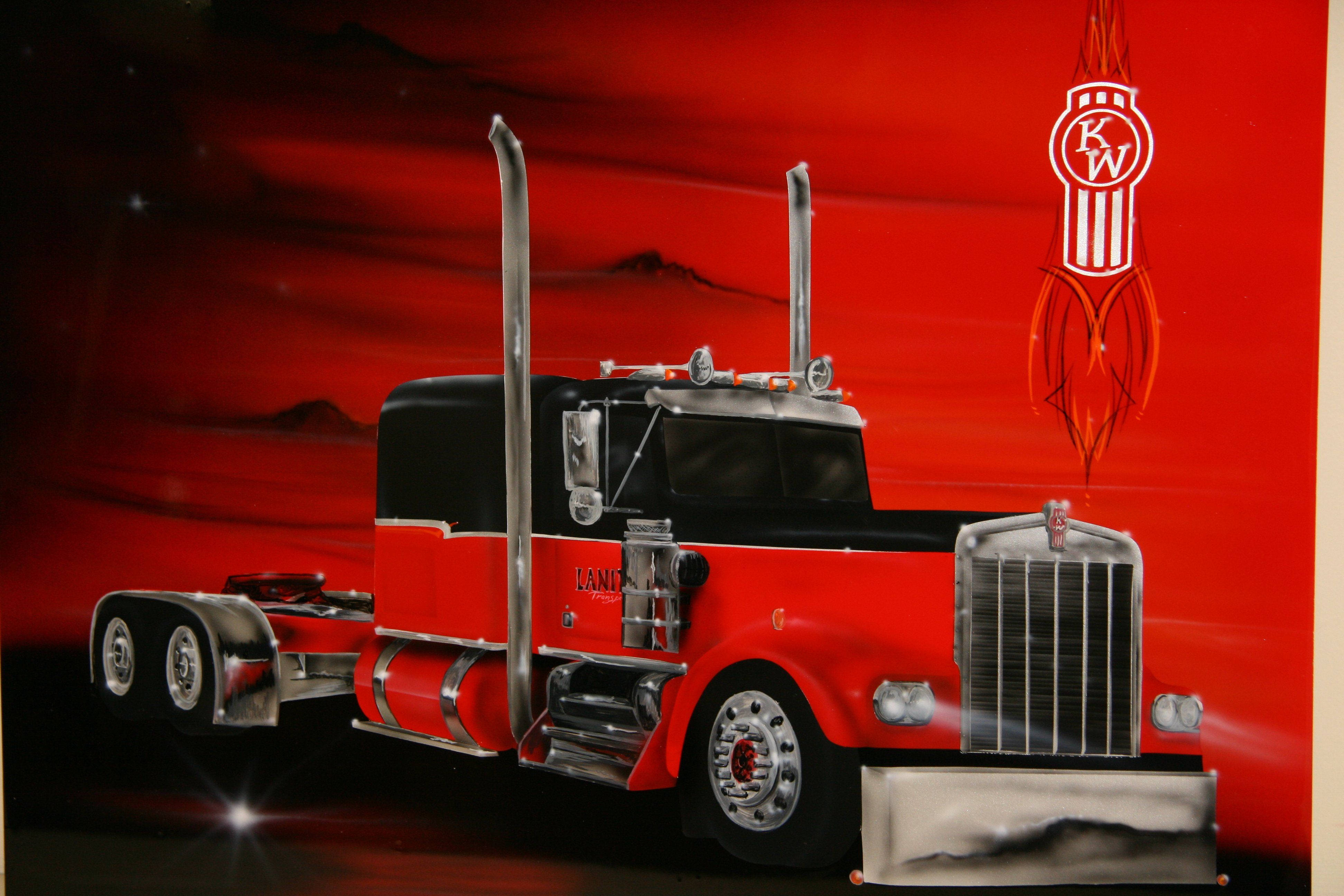 Kenworth 桌布 壁紙 — 一輛大膽的紅黑半掛卡車帶有鍍鉻裝飾，矗立在火紅的天空和遠山前。
