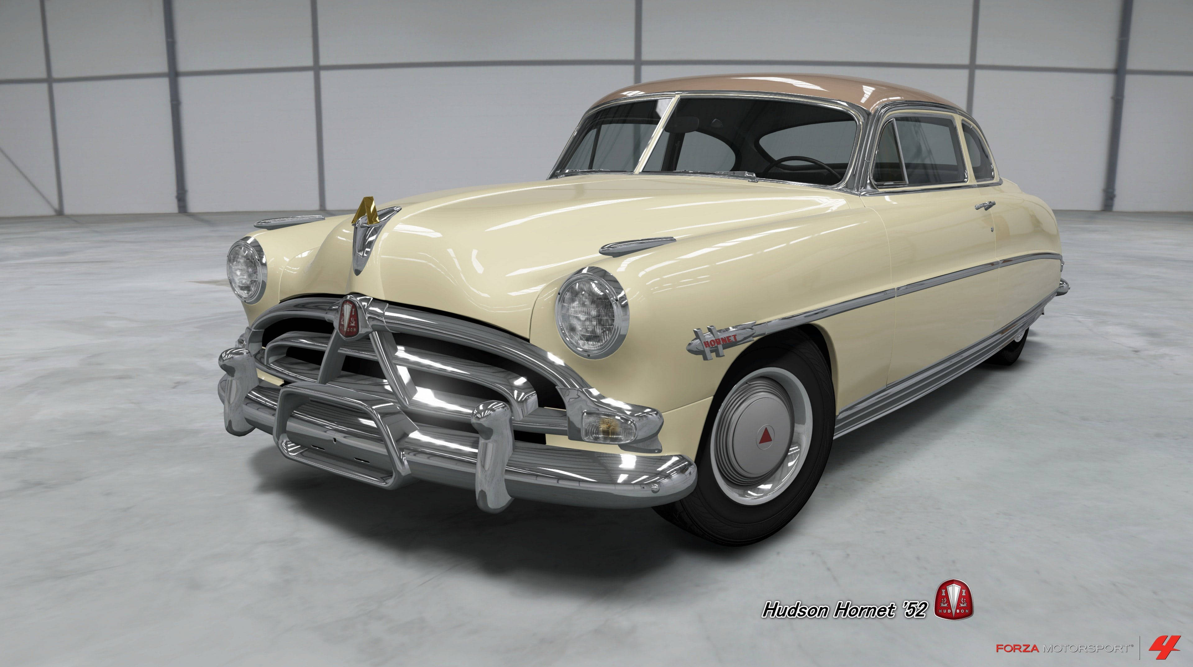 Horizon 桌布 壁紙 — 一輛奶油色和棕褐色的1952年Hudson Hornet經典汽車在簡約混凝土車庫的攝影棚燈光下閃閃發光。