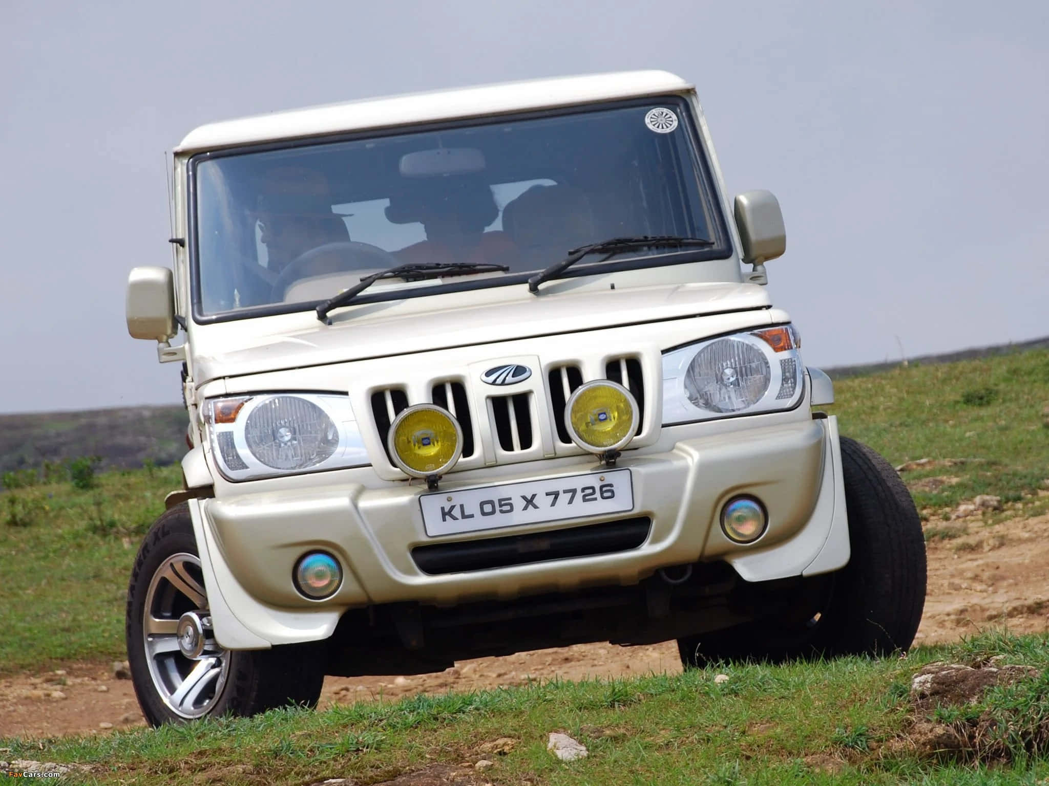 Mahindra 桌布 壁紙 — 一輛奶油色的Mahindra Scorpio SUV停泊在長滿青草的山坡上，背景是晴朗的天空。