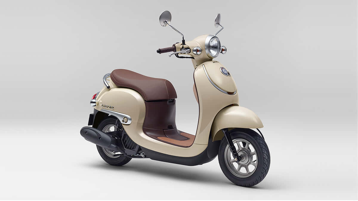 scooter 桌布 壁紙 — 一輛奶油色的Piaggio機車，配備棕色皮革座椅，在極簡灰色工作室背景前蓄勢待發。