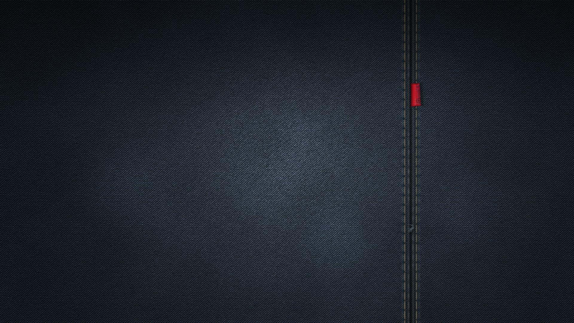 Jeans 桌布 壁紙 — 一輛孤獨的紅色汽車在柔和燈光下行駛在一條刻在深色牛仔布上的狹窄道路上。