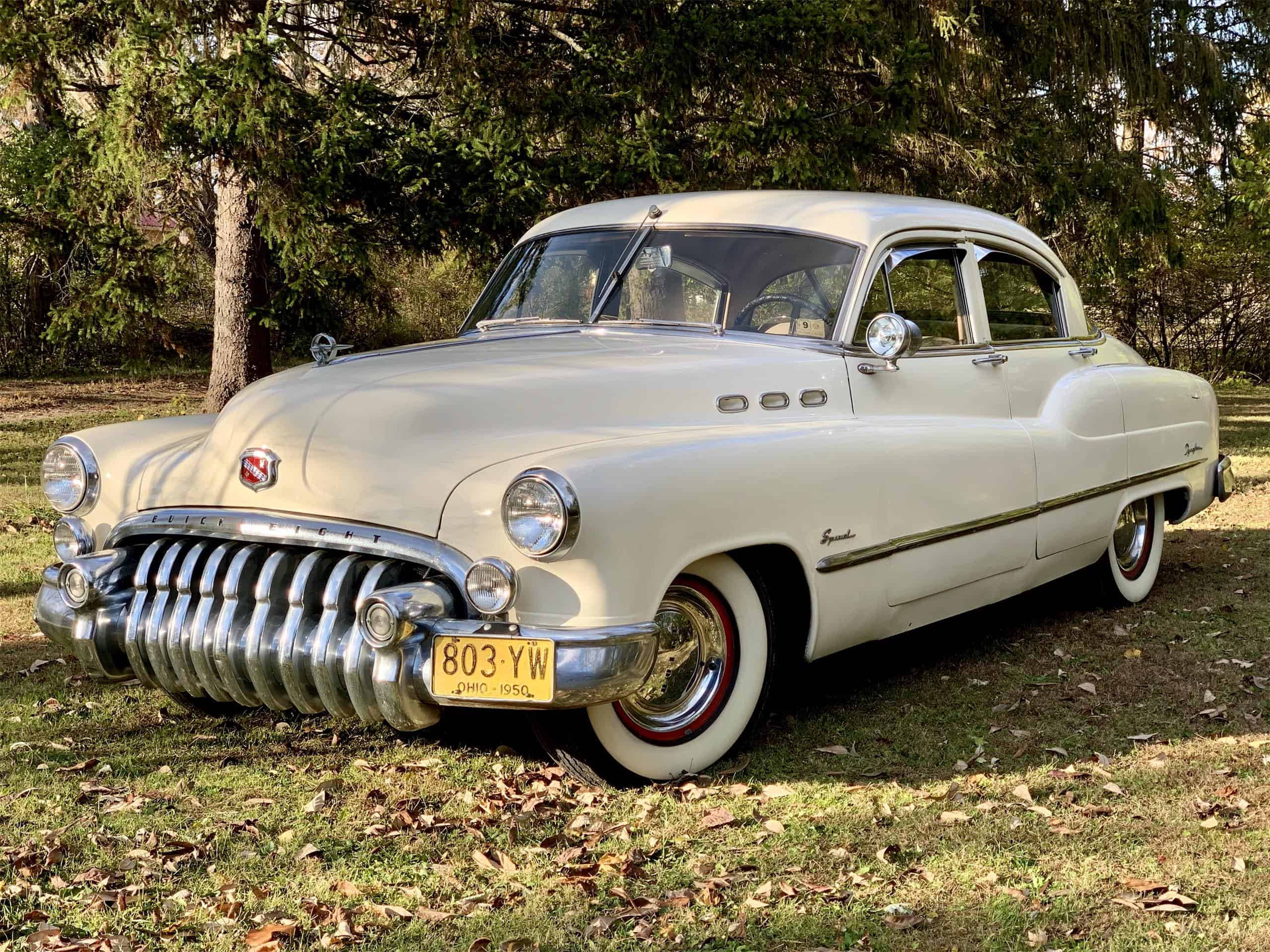 Buick 桌布 壁紙 — 一輛完美的奶油色1950年Buick Special在陽光下閃閃發光，停泊在散落落葉的草地上。