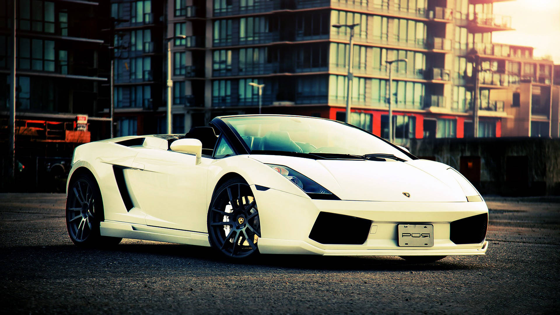 4K Lamborghini 桌布 壁紙 — 一輛完美的白色藍寶堅尼Gallardo Spyder停在柏油路上，背後現代建築在溫暖的夕陽光中閃耀。