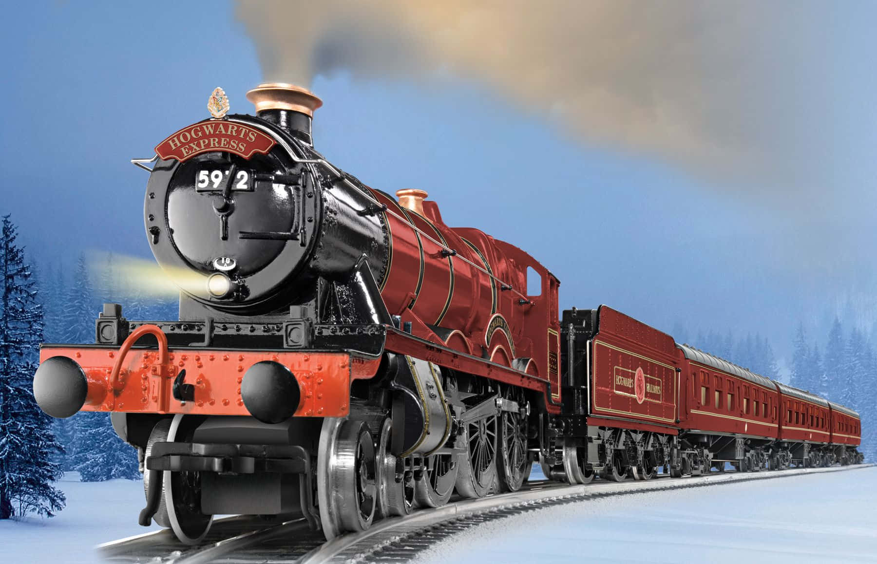 Hogwarts Express 桌布 壁紙 — 一輛宏偉的紅色霍格華茲特快蒸汽火車在晴朗的藍天下穿過白雪皚皚的冬季森林。