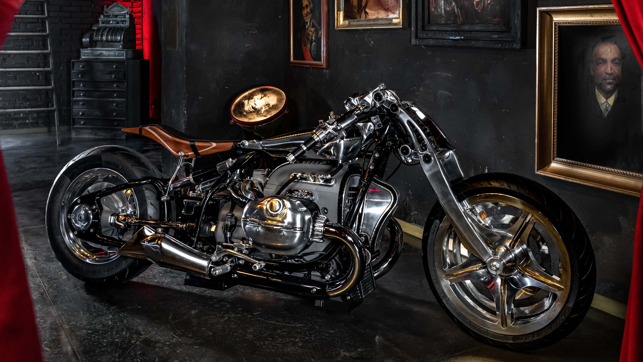 桌布 壁紙 — 一輛定制鍍鉻摩托車，配有棕色皮革座椅，展示在一個光線昏暗的房間裡，房間裝飾著復古肖像和紅色窗簾。