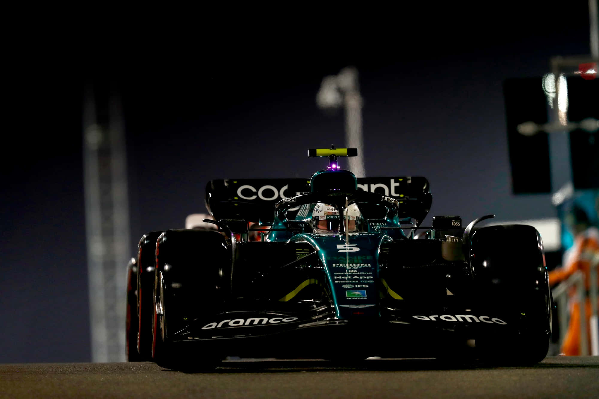 Formula One 桌布 壁紙 — 一輛帶有'Aramco'品牌標誌的時尚黑色和藍綠色一級方程式賽車，在夜間的賽道上被照亮。
