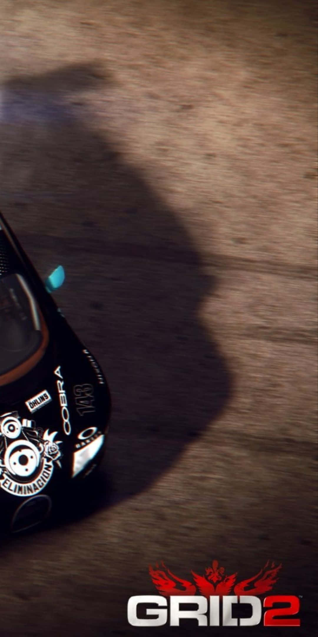 game 桌布 壁紙 — 一輛帶有 'Cobra' 貼紙的黑色賽車在塵土飛揚的賽道上疾馳，在戲劇性的燈光下投下長長的影子。
