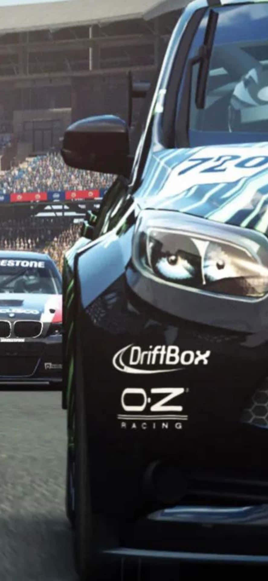 電玩遊戲 桌布 壁紙 — 一輛帶有 'DriftBox' 和 'O:Z Racing' 貼紙的黑色甩尾車在賽道上比賽，背景有群眾。