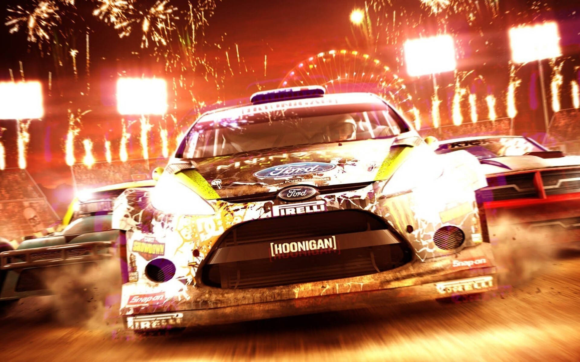泥土 桌布 壁紙 — 一輛帶有 'Hoonigan' 品牌的福特拉力賽車在煙火和體育場燈光下於夜間泥地賽道上飛馳。
