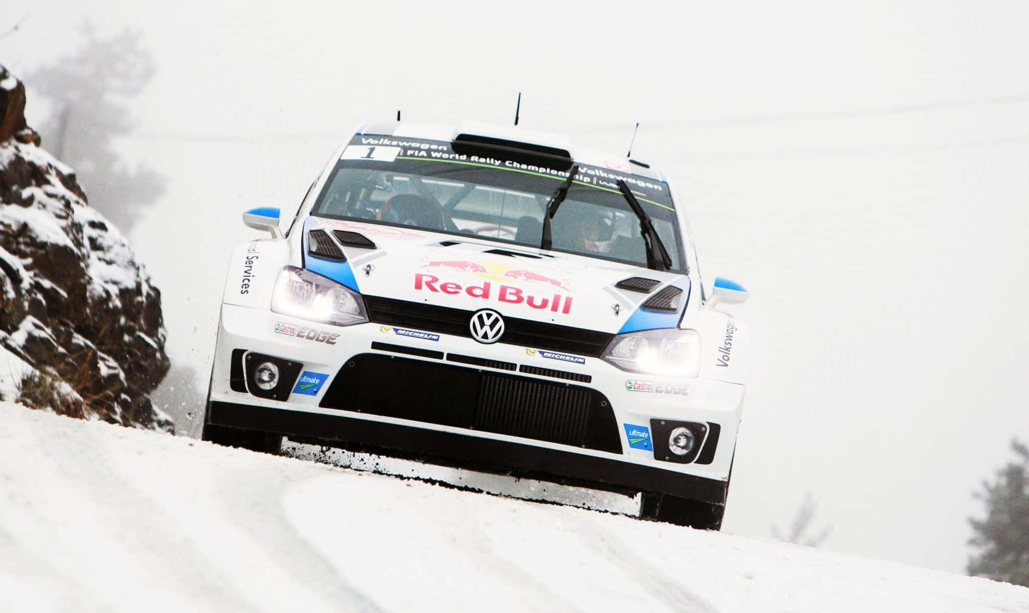 Ice Racing 桌布 壁紙 — 一輛帶有Red Bull品牌標誌的白色福斯偉根拉力賽車在積雪的山路上飛馳，揚起雪花。