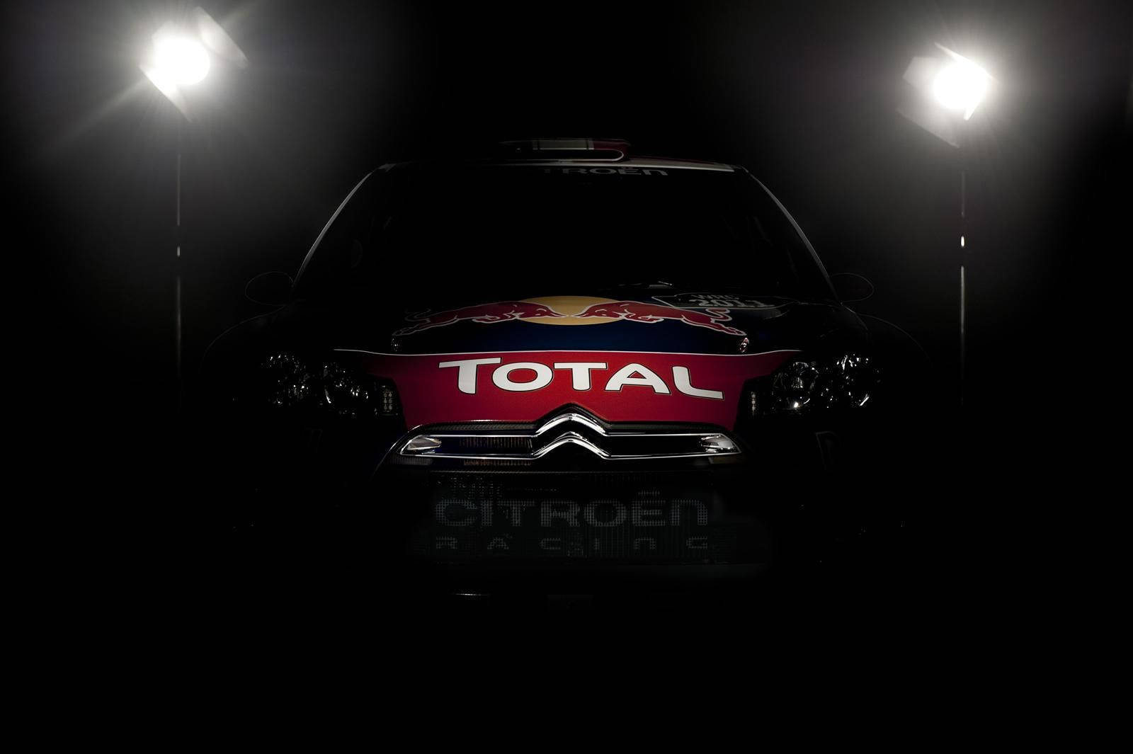 Citroen 桌布 壁紙 — 一輛帶有Total和Red Bull品牌的雪鐵龍拉力賽車在黑暗的攝影棚中從上方戲劇性地照亮。