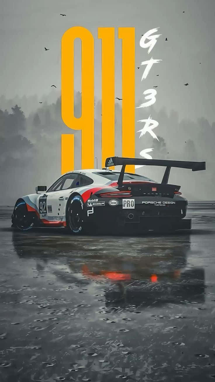 Porsche 911 GT3RS 壁紙 — 一輛帶有大型尾翼和92號的保時捷911 GT3 RS賽車停在潮濕的路面上，反射出紅白藍塗裝，灰色天空下鳥兒在巨大的黃色911和白色GT3 RS文字附近飛翔。