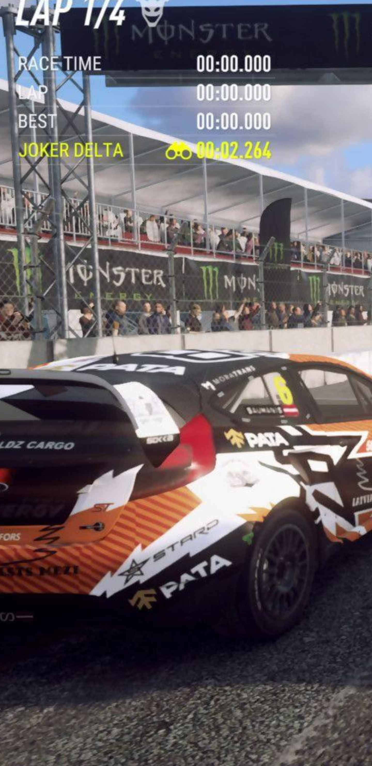 Android Dirt Rally 桌布 壁紙 — 一輛帶有橙色、黑色和白色塗裝的拉力賽車在礫石賽道上行駛，背景有觀眾和Monster Energy品牌標誌。