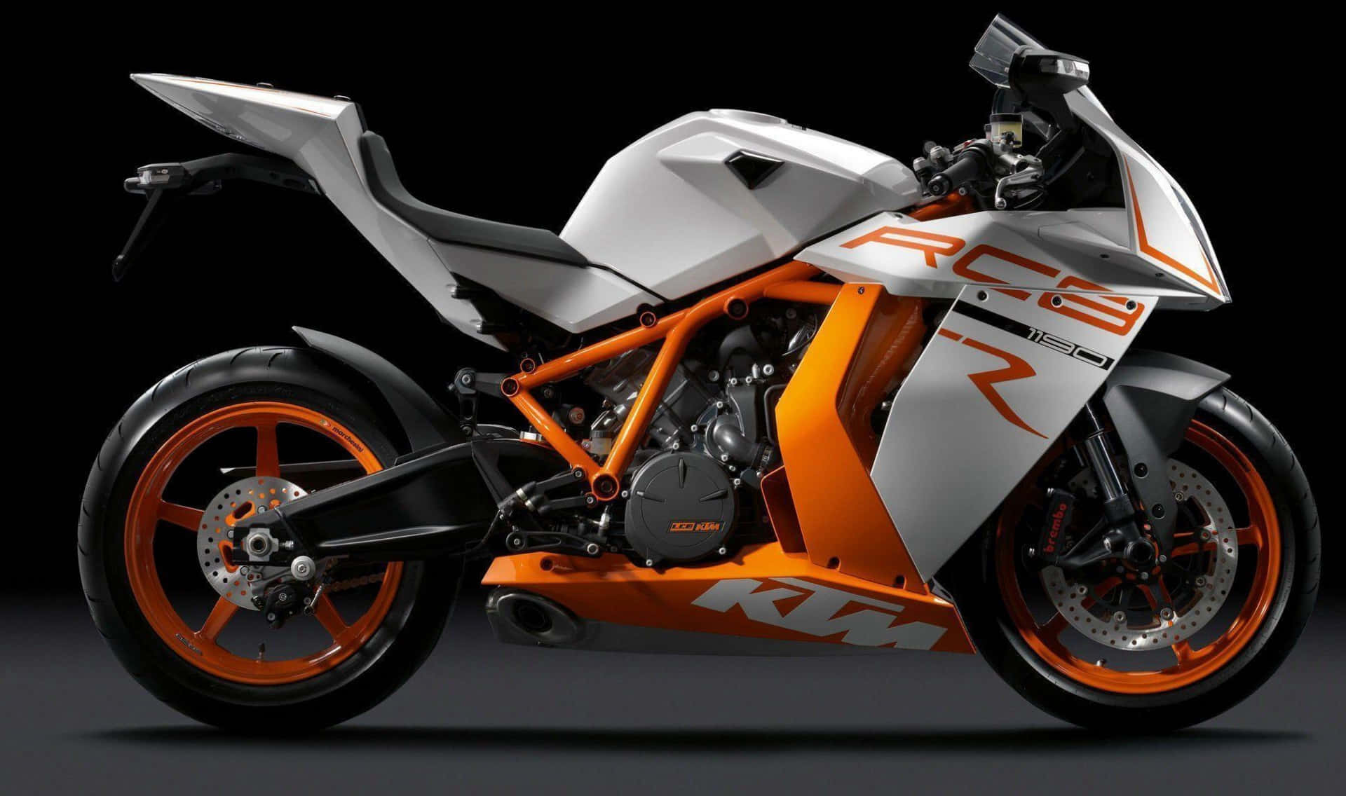 機車 桌布 壁紙 — 一輛帶有橙色和白色點綴的時尚KTM RC8 R摩托車，在黑色背景的戲劇性工作室燈光下展示。