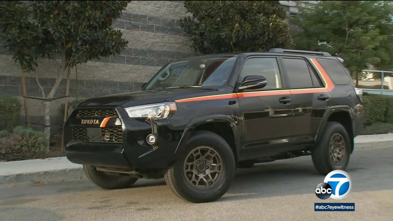 黑色豐田4Runner SUV帶橙色條紋停放在街道上。 — Toyota Supra Mk4 壁紙