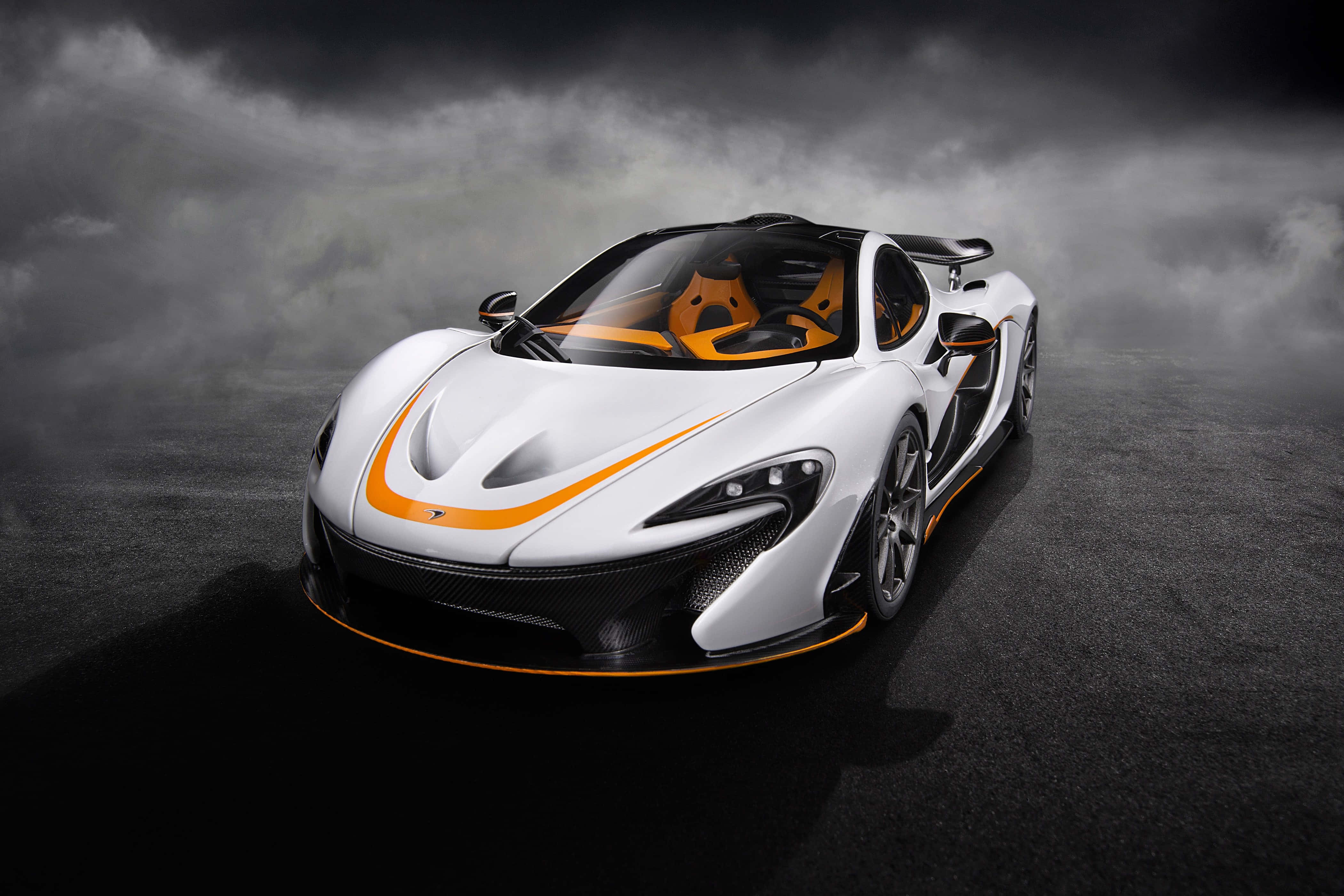 麥拉倫 桌布 壁紙 — 一輛帶有橙色點綴的白色McLaren跑車在黑暗潮濕的道路上，在戲劇性的暴風雲下閃閃發光。