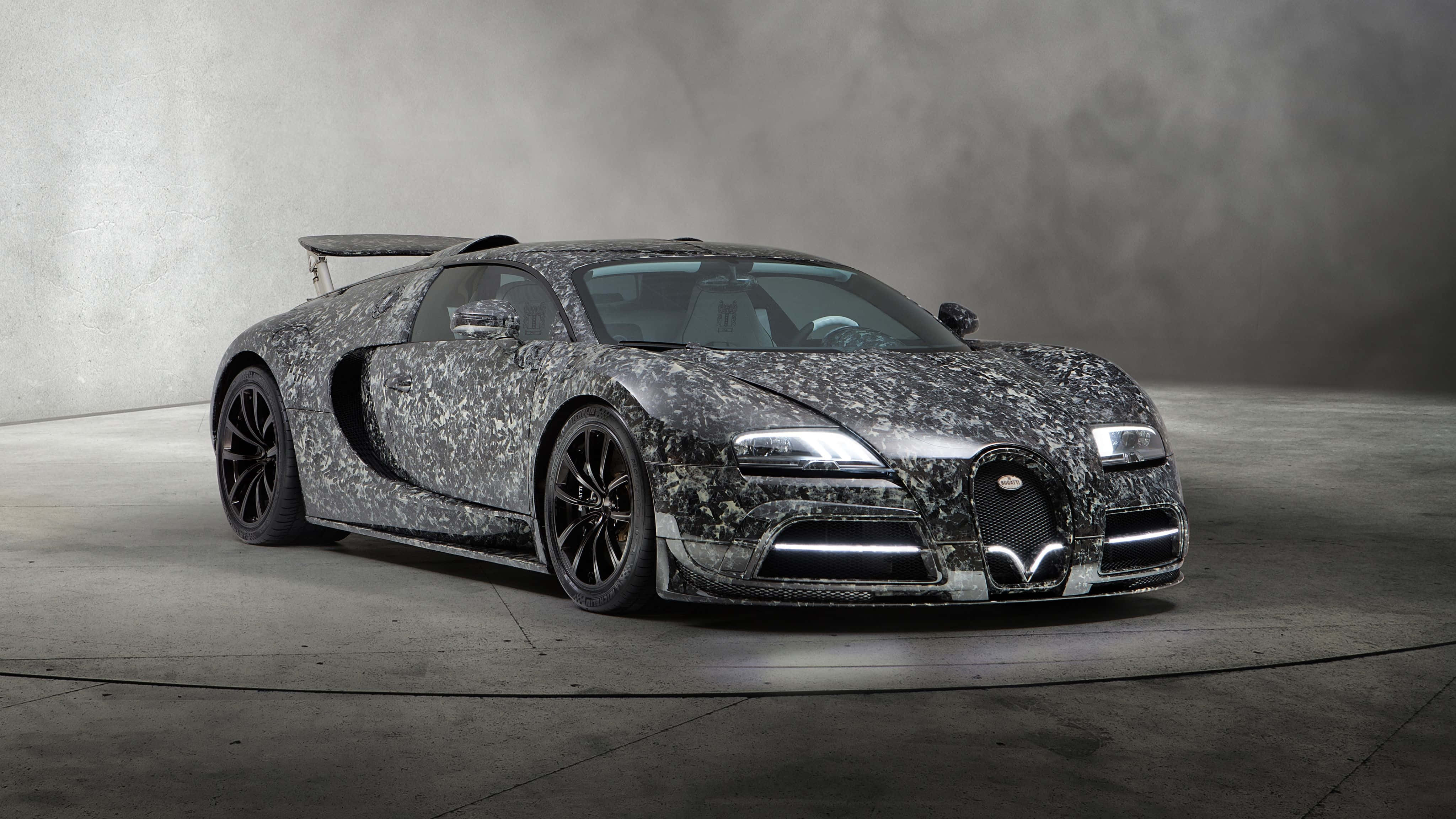 Diamond Car 桌布 壁紙 — 一輛帶有灰色斑點迷彩圖案的Bugatti超級跑車，在極簡混凝土工作室的戲劇性燈光下展示。
