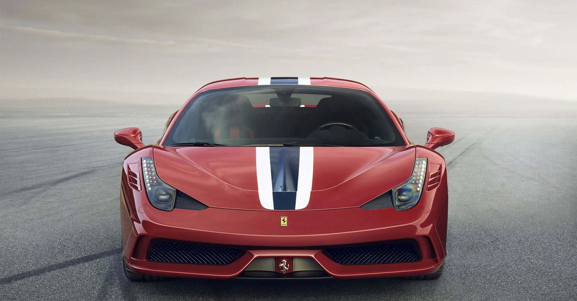 Ferrari 458 Speciale 桌布 壁紙 — 一輛帶有白色和藍色賽車條紋的紅色法拉利跑車在陰天、霧氣瀰漫的灰色賽道上向前行駛。