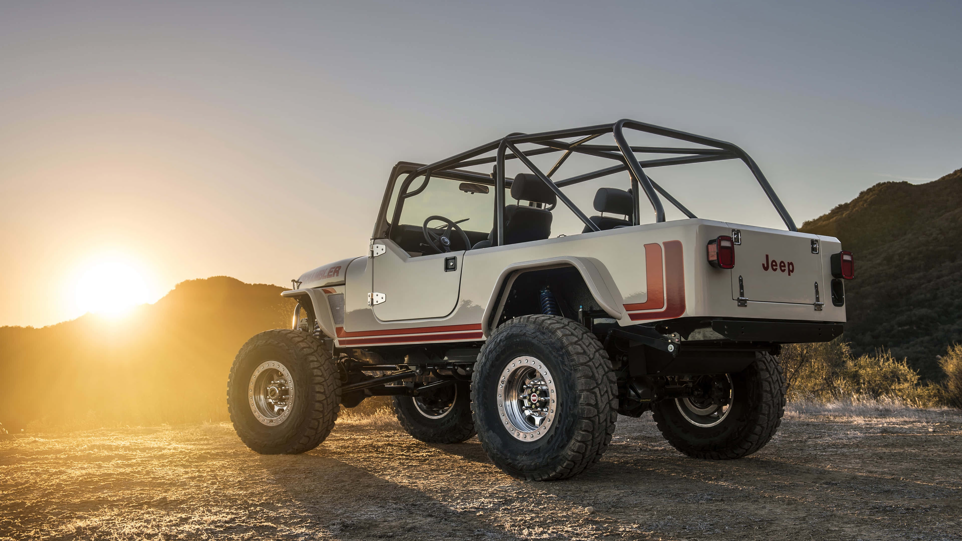 Jeep Cj 桌布 壁紙 — 一輛帶有紅色條紋的白色Jeep Wrangler在日落時分停在塵土飛揚的地形上，金色的光線投下長長的陰影。