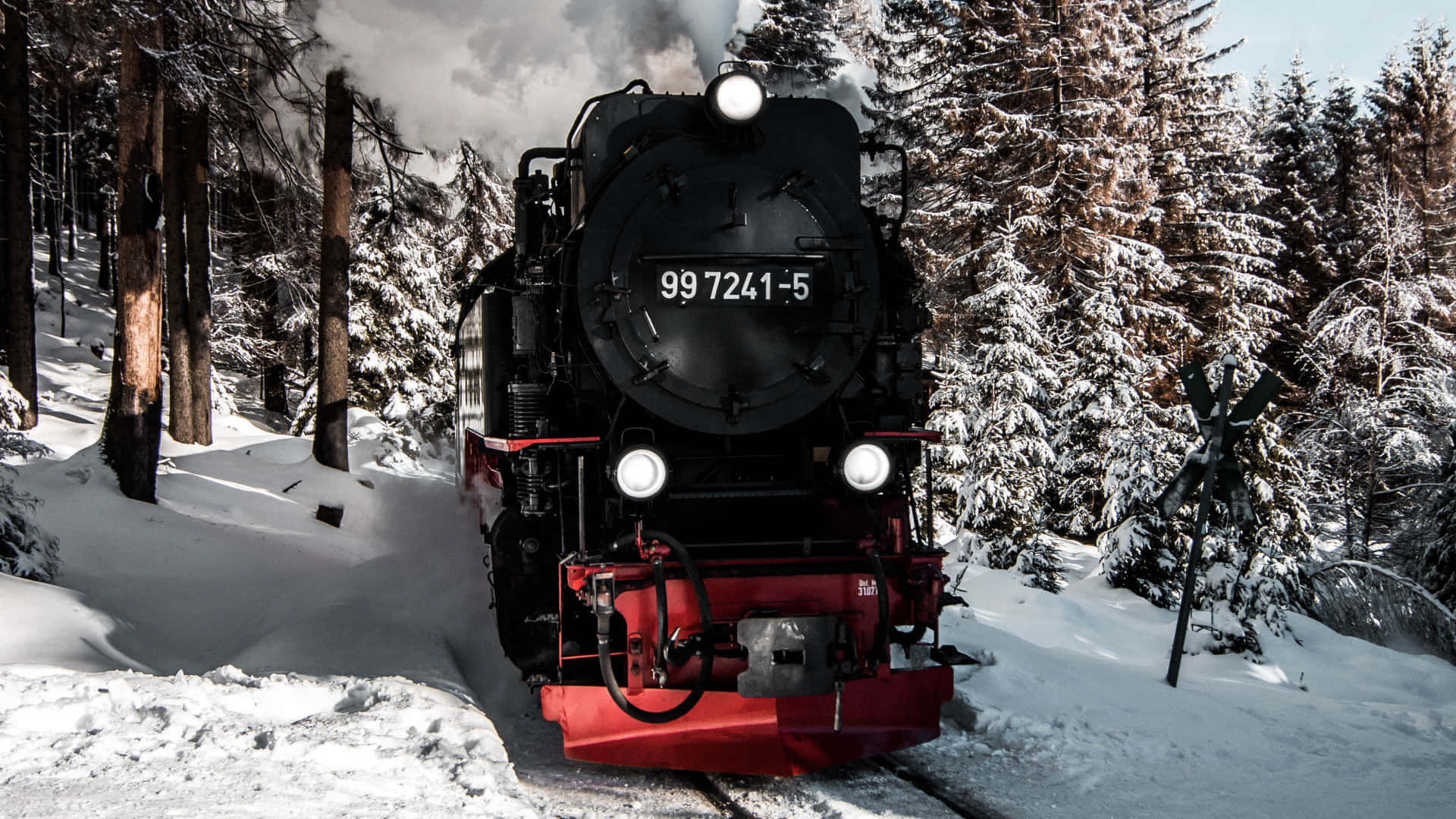 Hogwarts Express 桌布 壁紙 — 一輛帶有紅色裝飾的黑色蒸汽火車頭穿過白雪覆蓋的森林，在冬季軌道上行駛時噴出蒸汽。