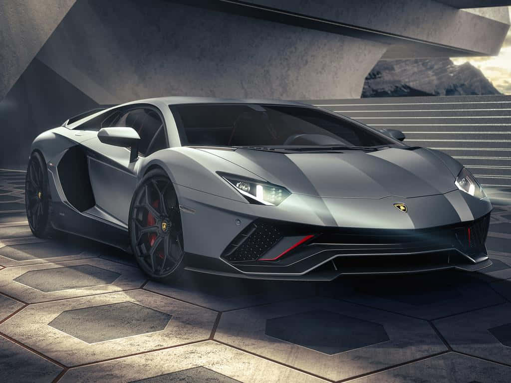 Lamborghini Aventador 桌布 壁紙 — 一輛帶有紅色點綴的時尚銀色藍寶堅尼Aventador停放在現代混凝土結構下的六角形混凝土上。