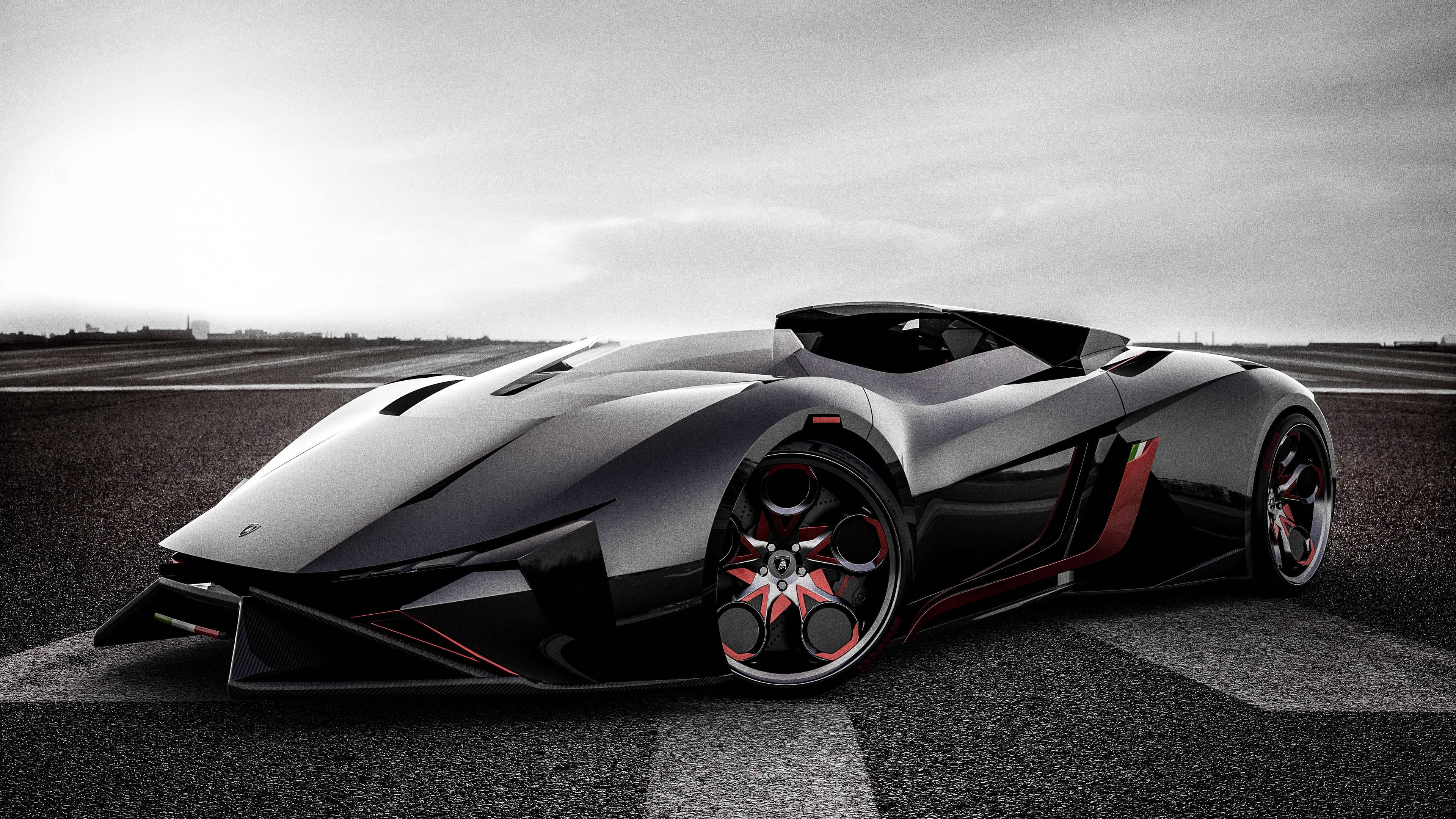 Cool Car 桌布 壁紙 — 一輛帶有紅色點綴的時尚黑色跑車停泊在多雲天空下的賽道上。