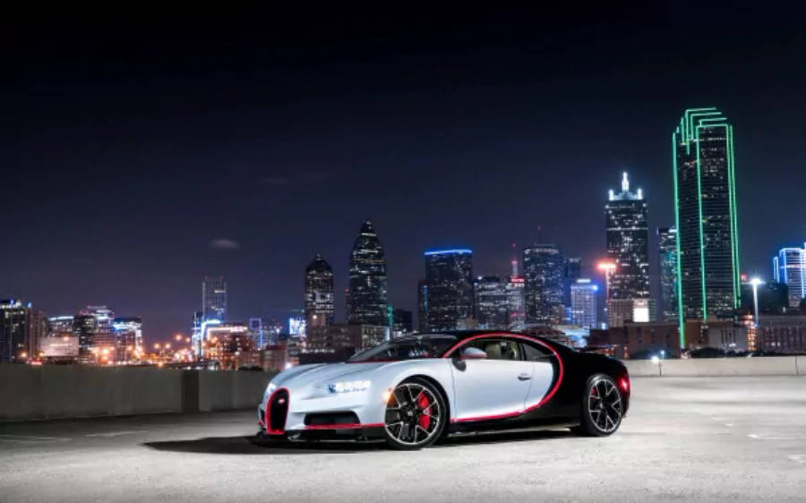 4K 桌布 壁紙 — 一輛帶有紅色點綴的銀黑色 Bugatti Chiron 在夜晚停泊在屋頂上，背景是充滿活力的城市天際線。