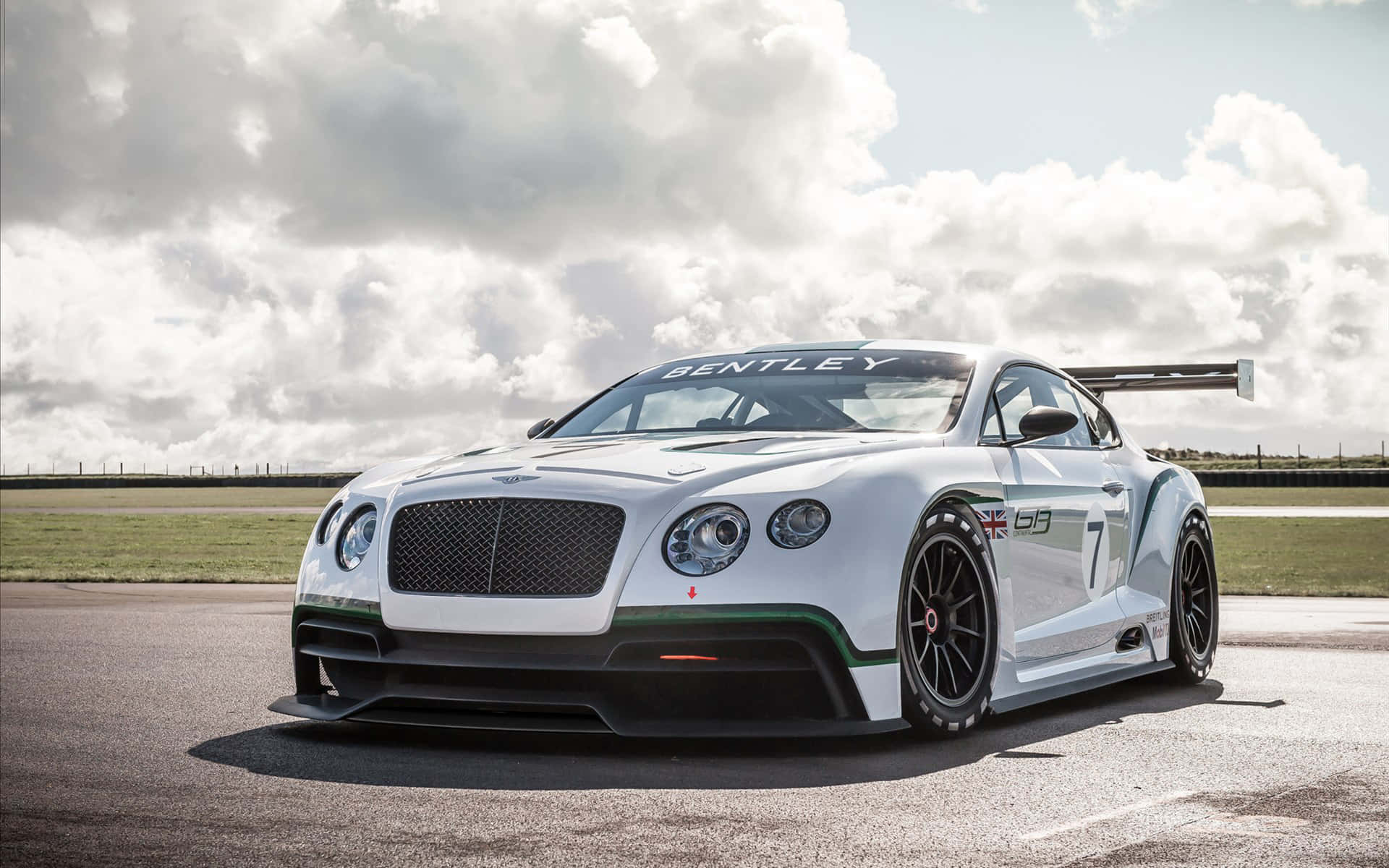 bentley HD 桌布 壁紙 — 一輛帶有綠色點綴和7號的白色賓利賽車，在陰天下的賽道上蓄勢待發。