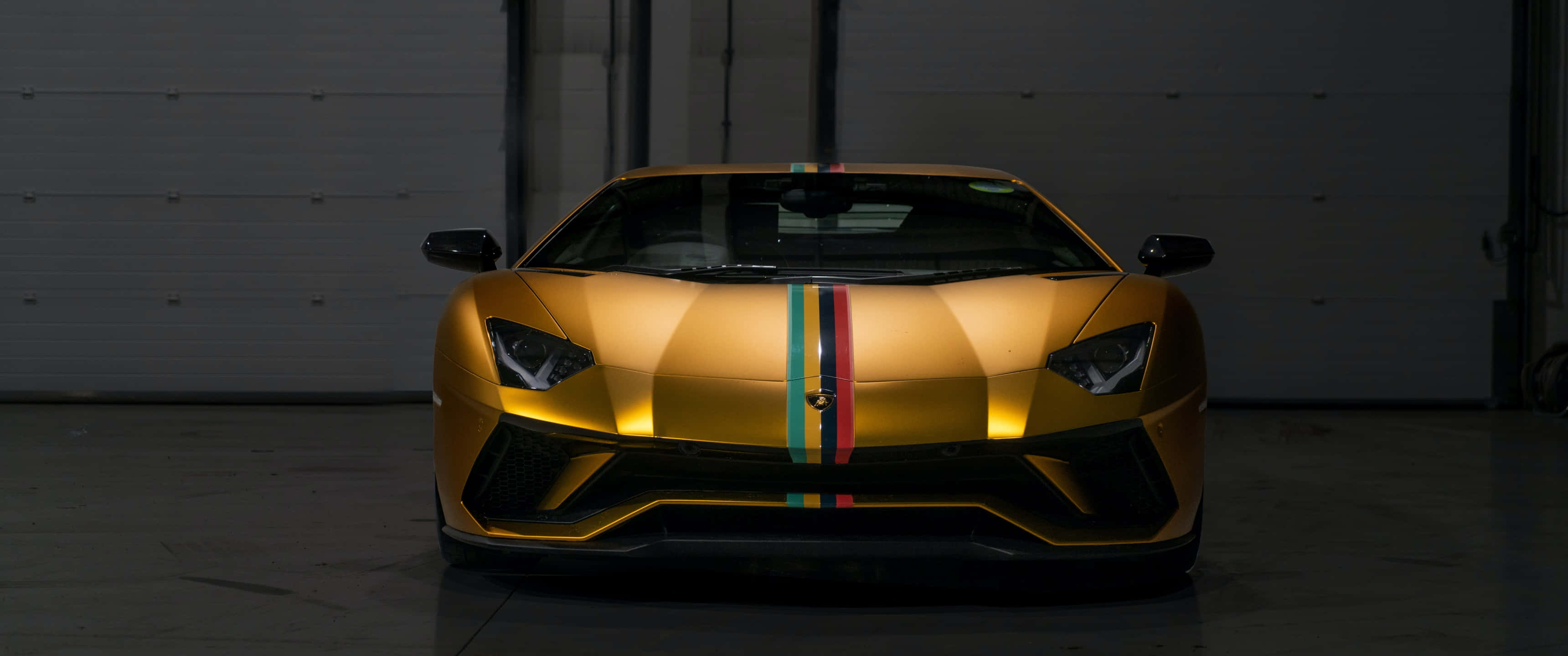 Gold Cars 桌布 壁紙 — 一輛帶有義大利三色條紋的金色藍寶堅尼Aventador在昏暗的工業車庫中於聚光燈下閃閃發光。