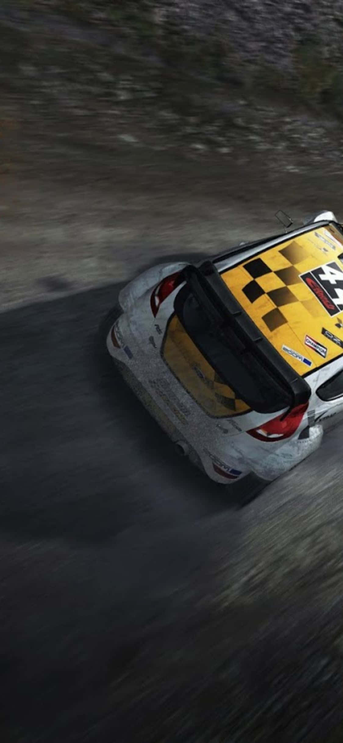 iPhone X Dirt Rally 桌布 壁紙 — 一輛帶有黃色棋盤格車頂的拉力賽車從俯視角度在泥濘的森林賽道上飛馳。